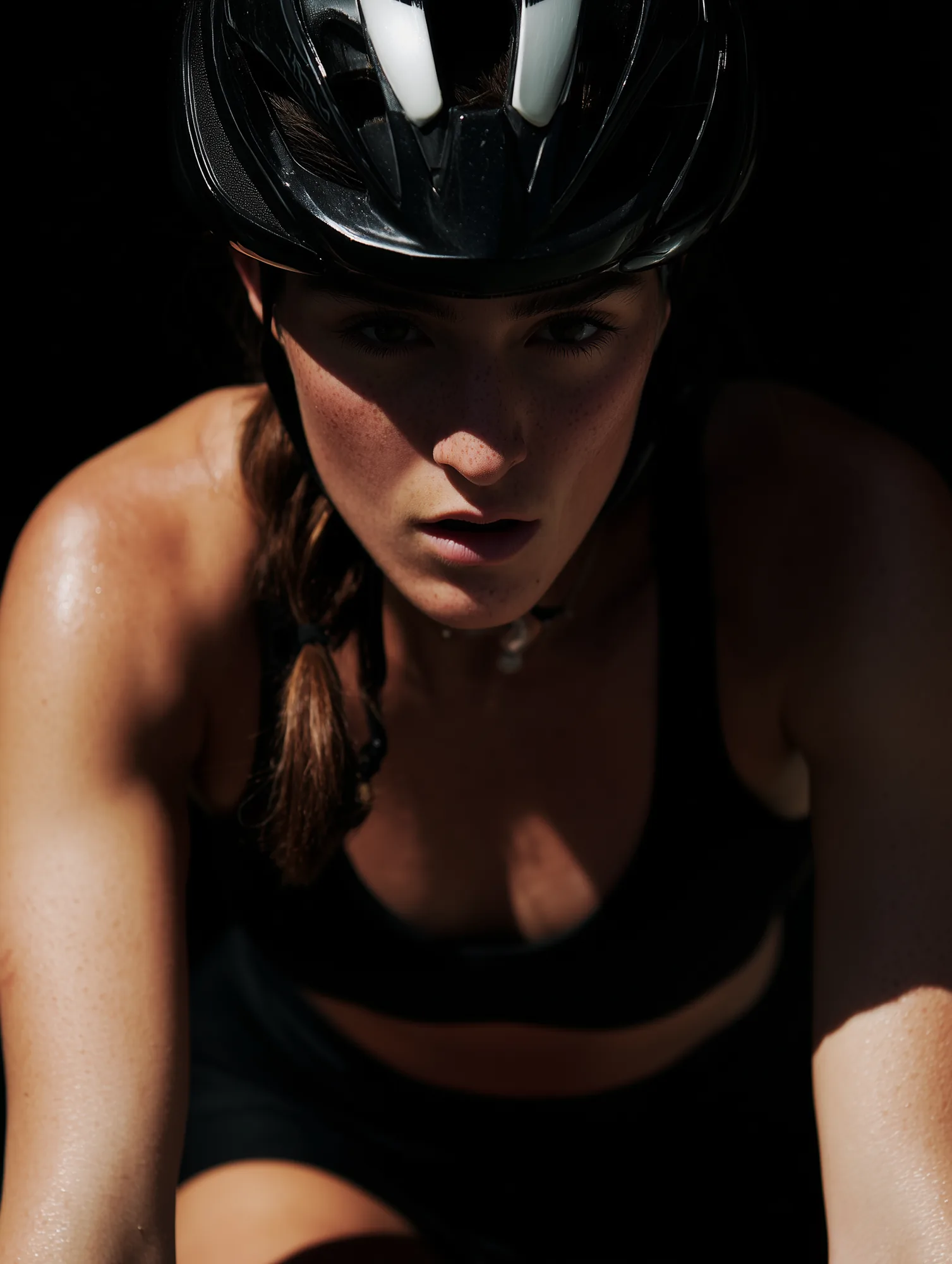 Cyclist in a black helmet, hard side light, mid-effort