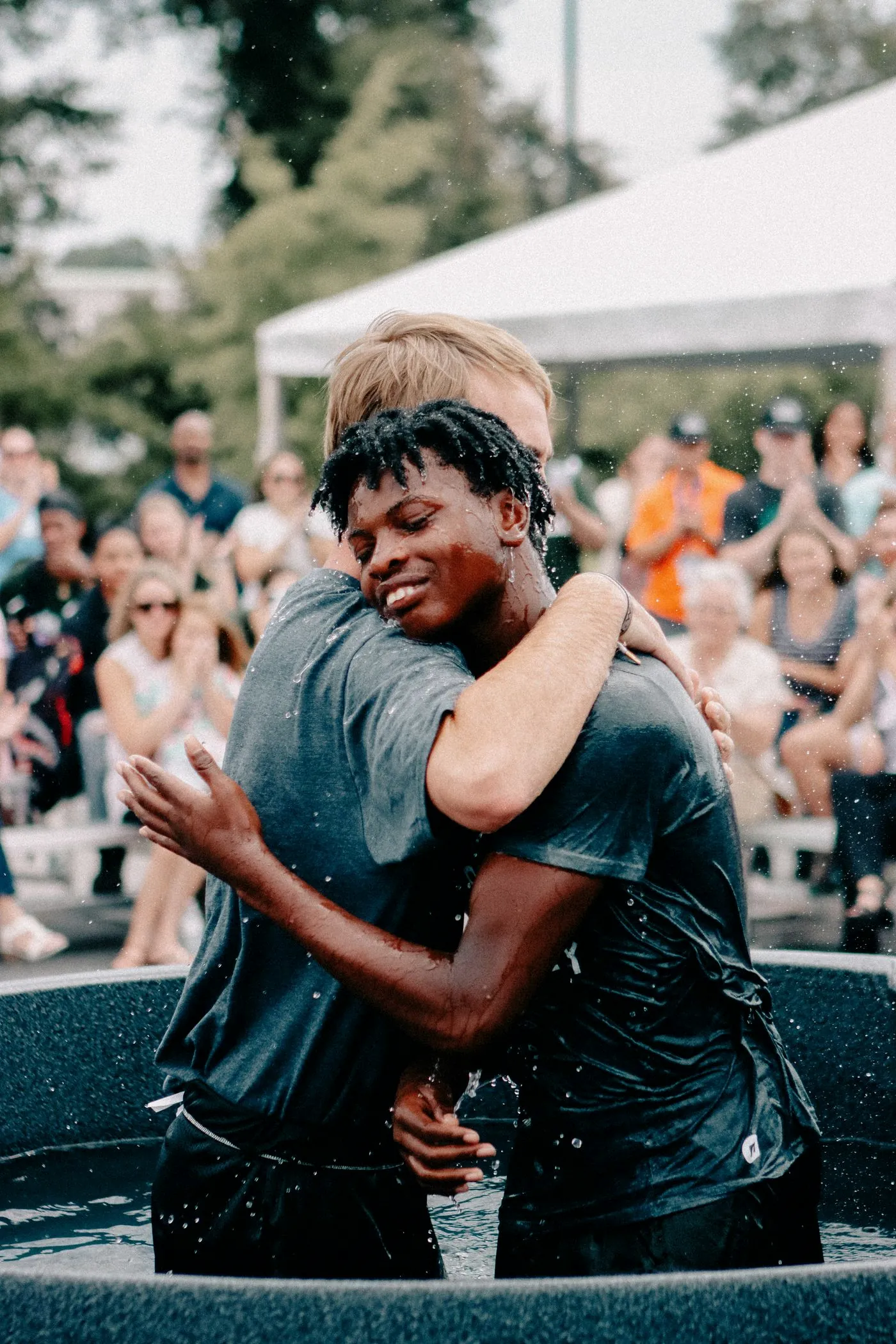 Two friends hugging after a baptism
