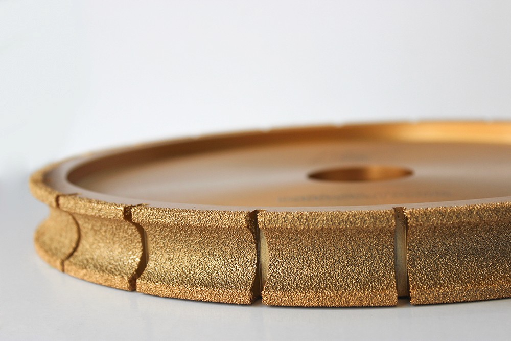 Side view of a golden Diamond Profiling Wheel, emphasizing the fine details and surface texture.