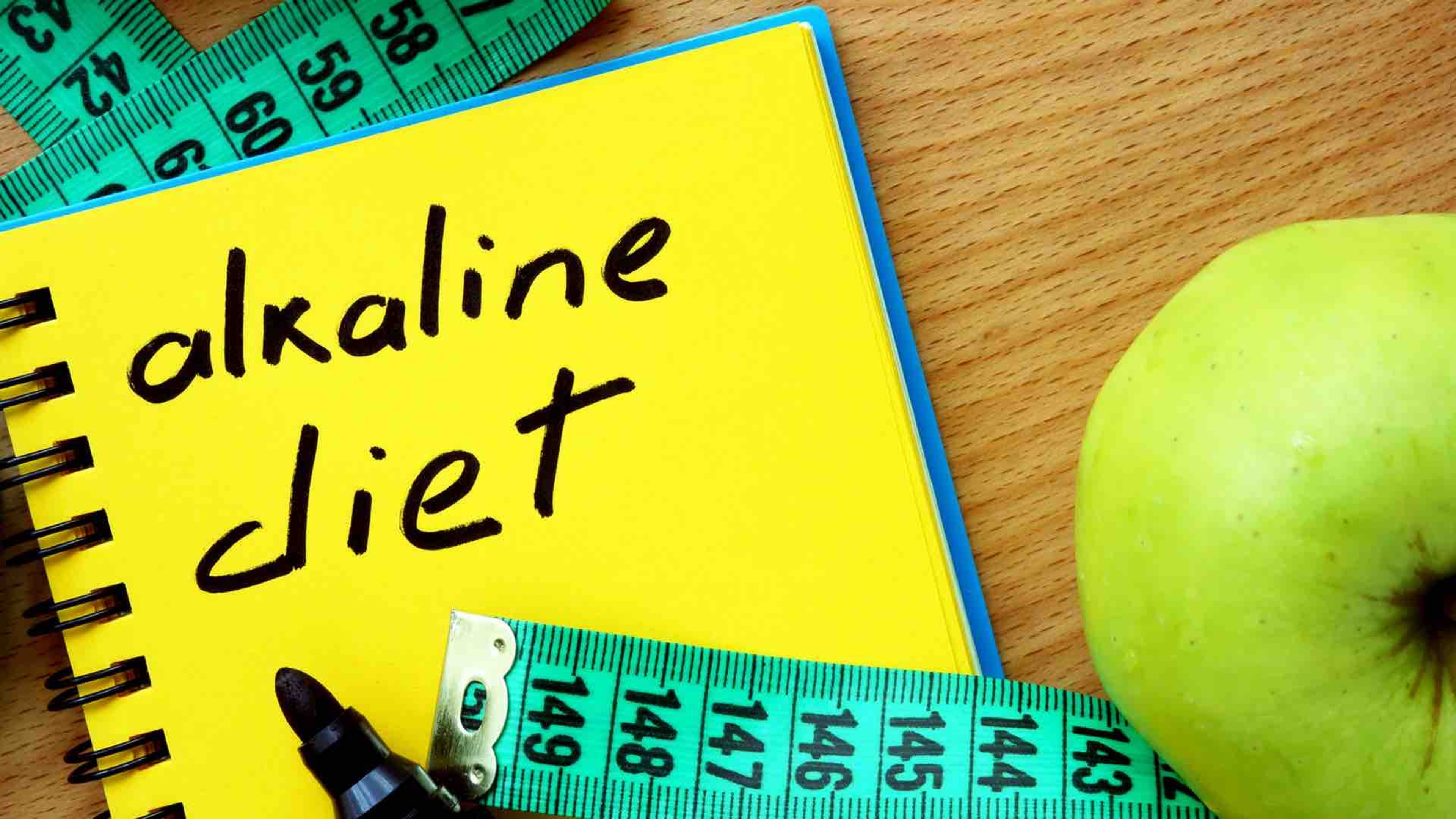 alkaline diet, measuring tape and a green apple