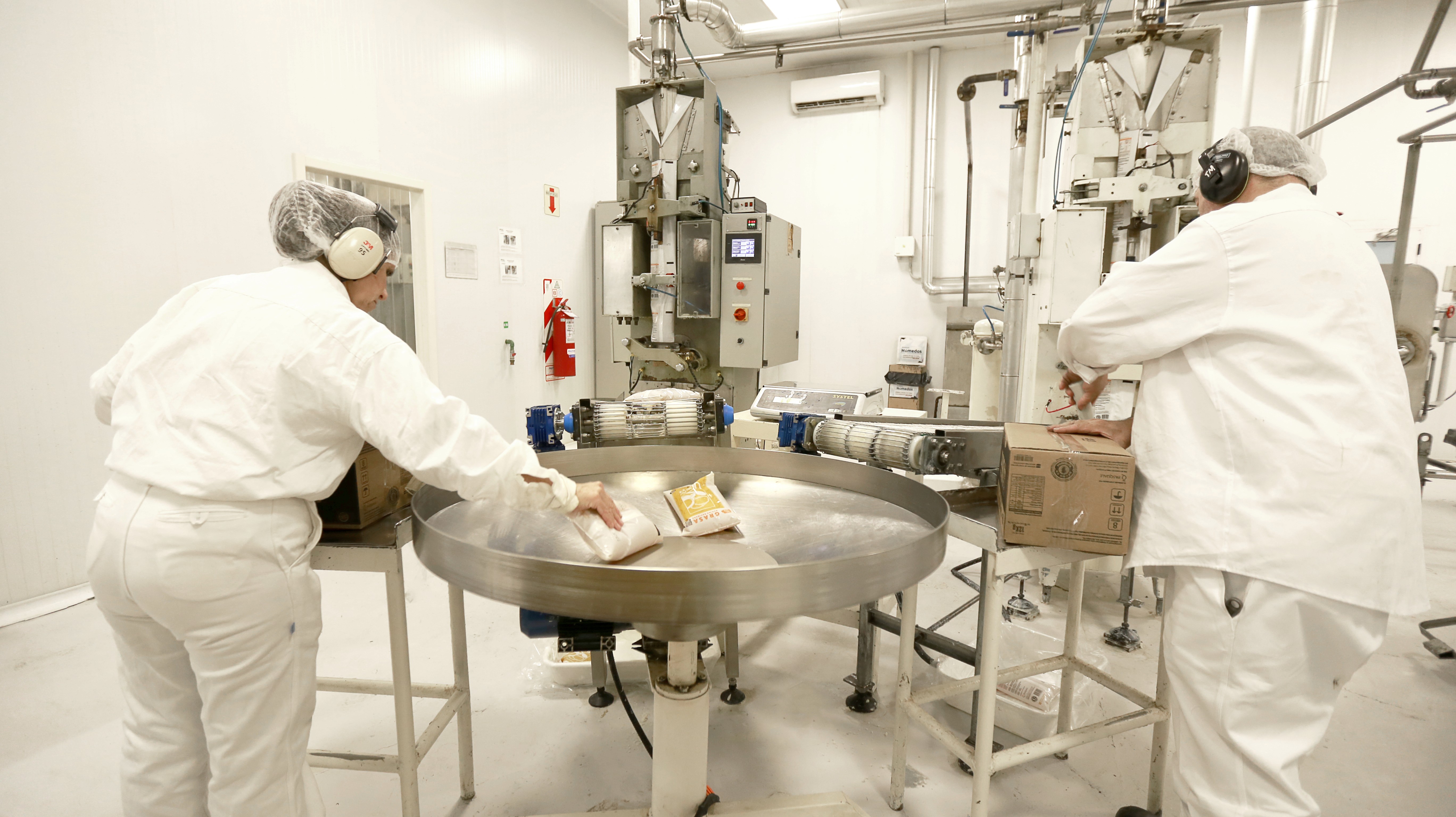 Técnicos de PQL supervisando la producción en planta industrial.