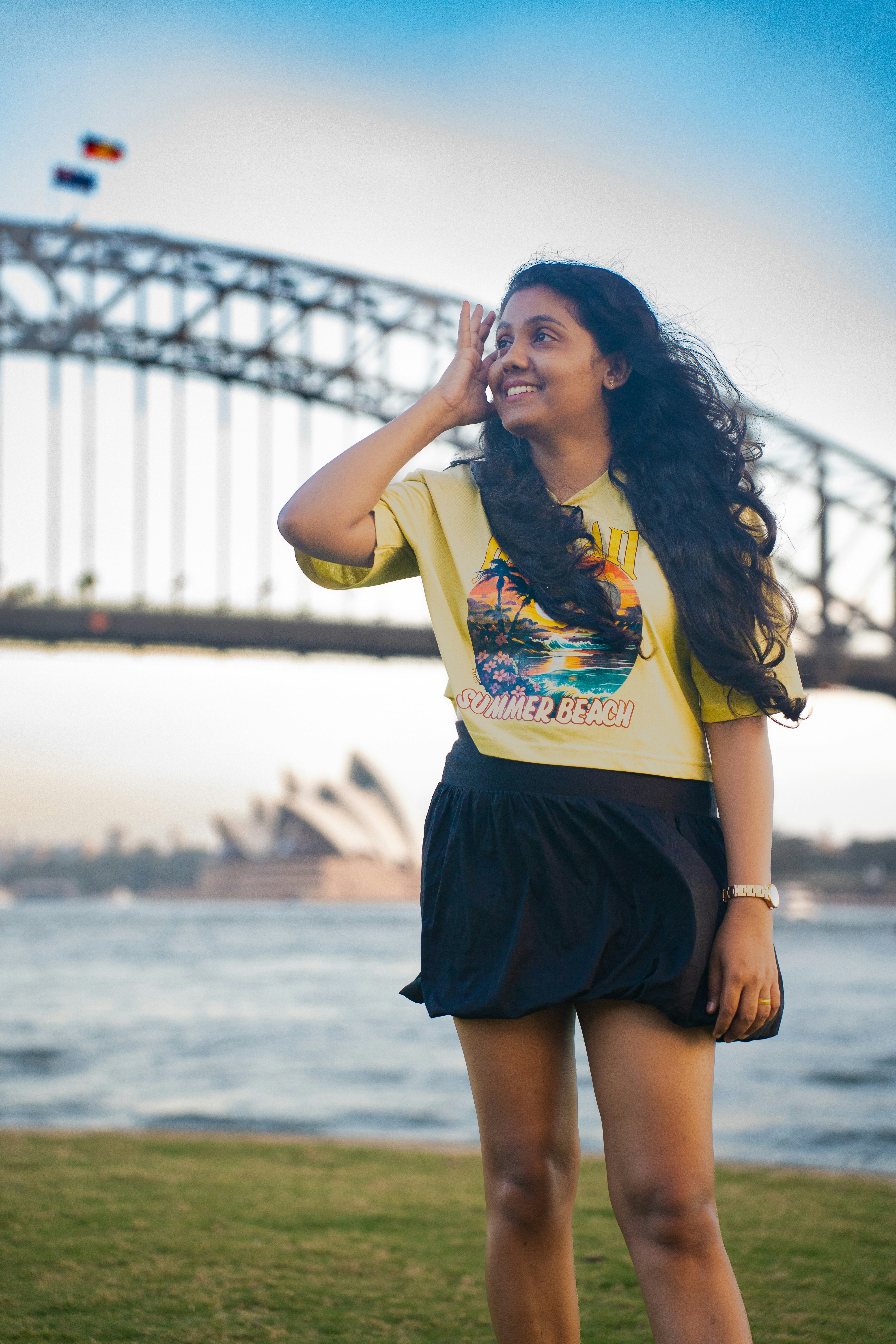 Smiling woman poses with sydney harbour bridge.