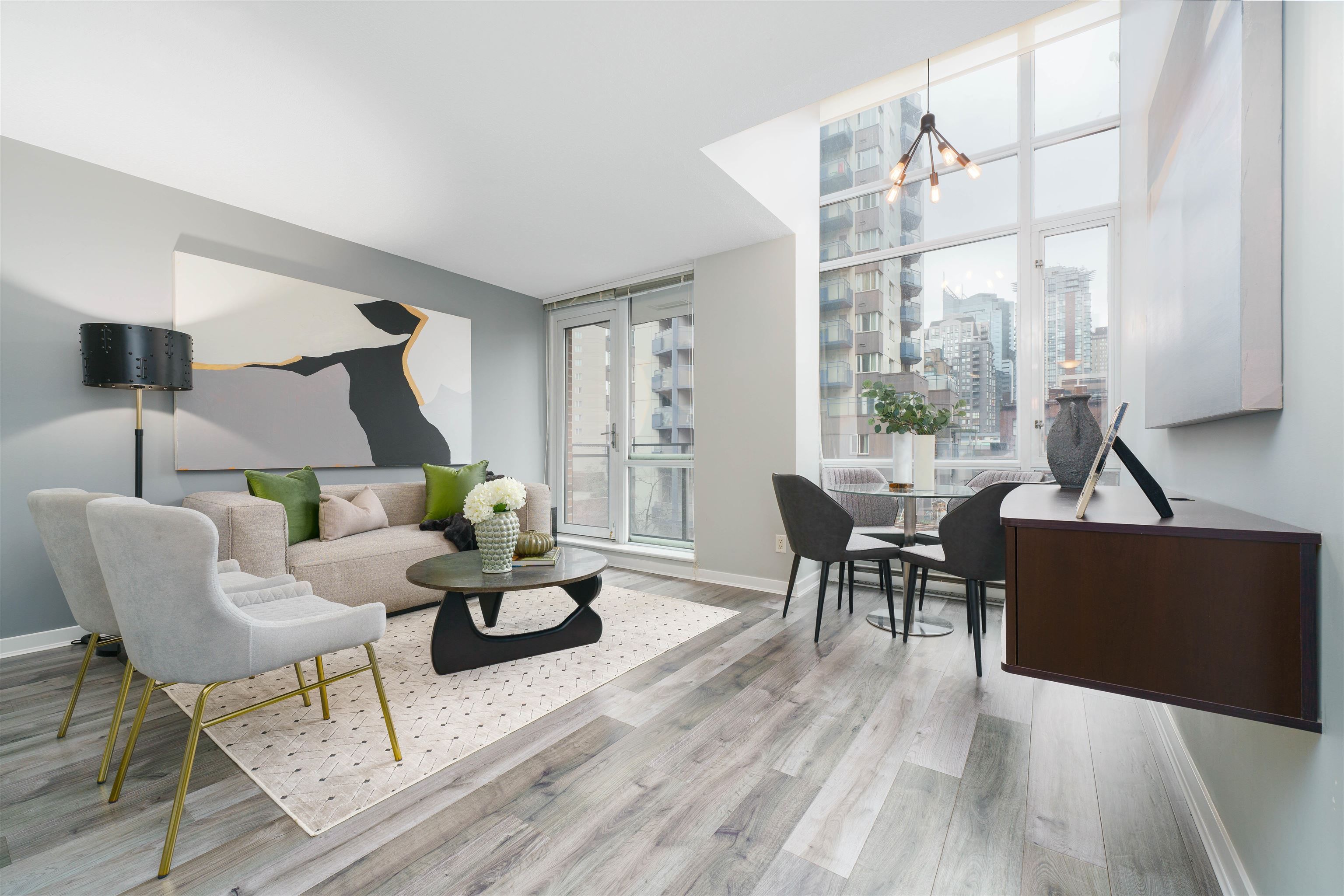 A bright, modern living room featuring plush seating, a dining area, and large windows allowing plenty of natural light.