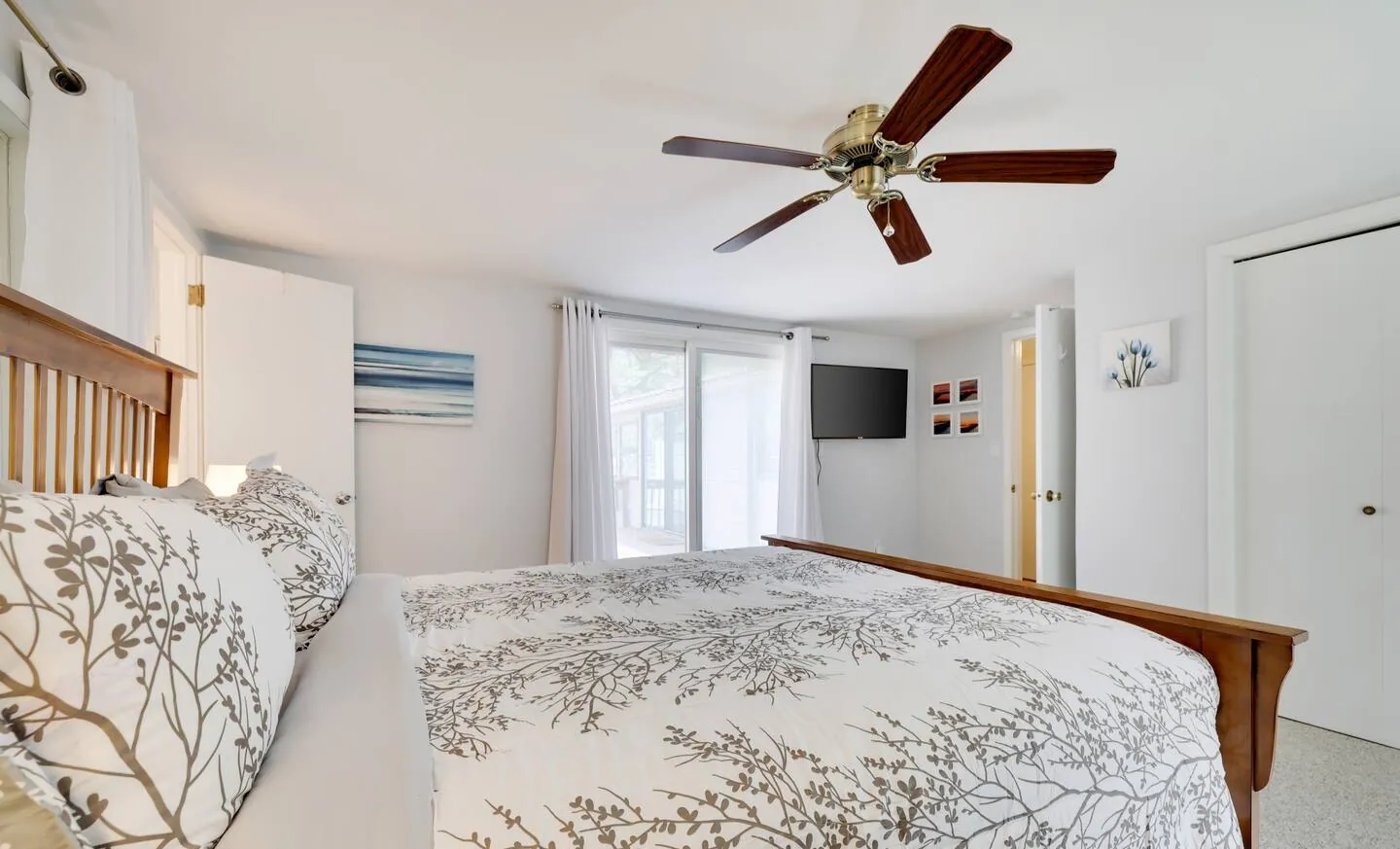Primary bedroom with branch print bedding and sliding doors to the yard at Relax in Style