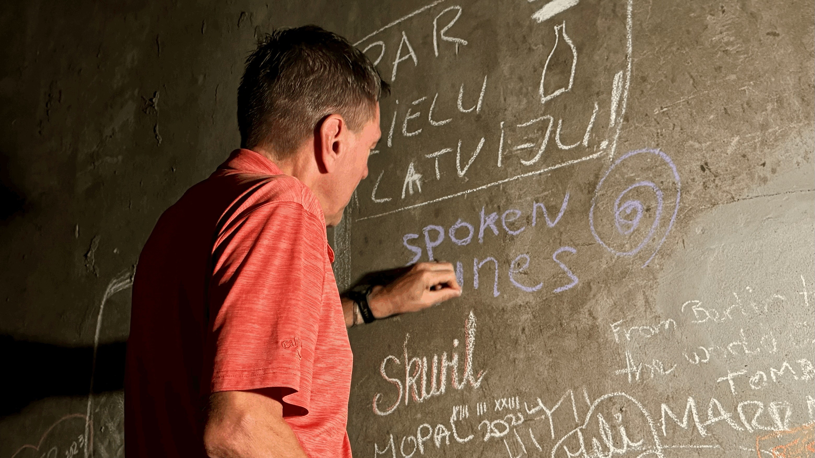Jan de Weerd writing Spoken Wines on a visitor wall inside Pulmary’s underground wine cellar