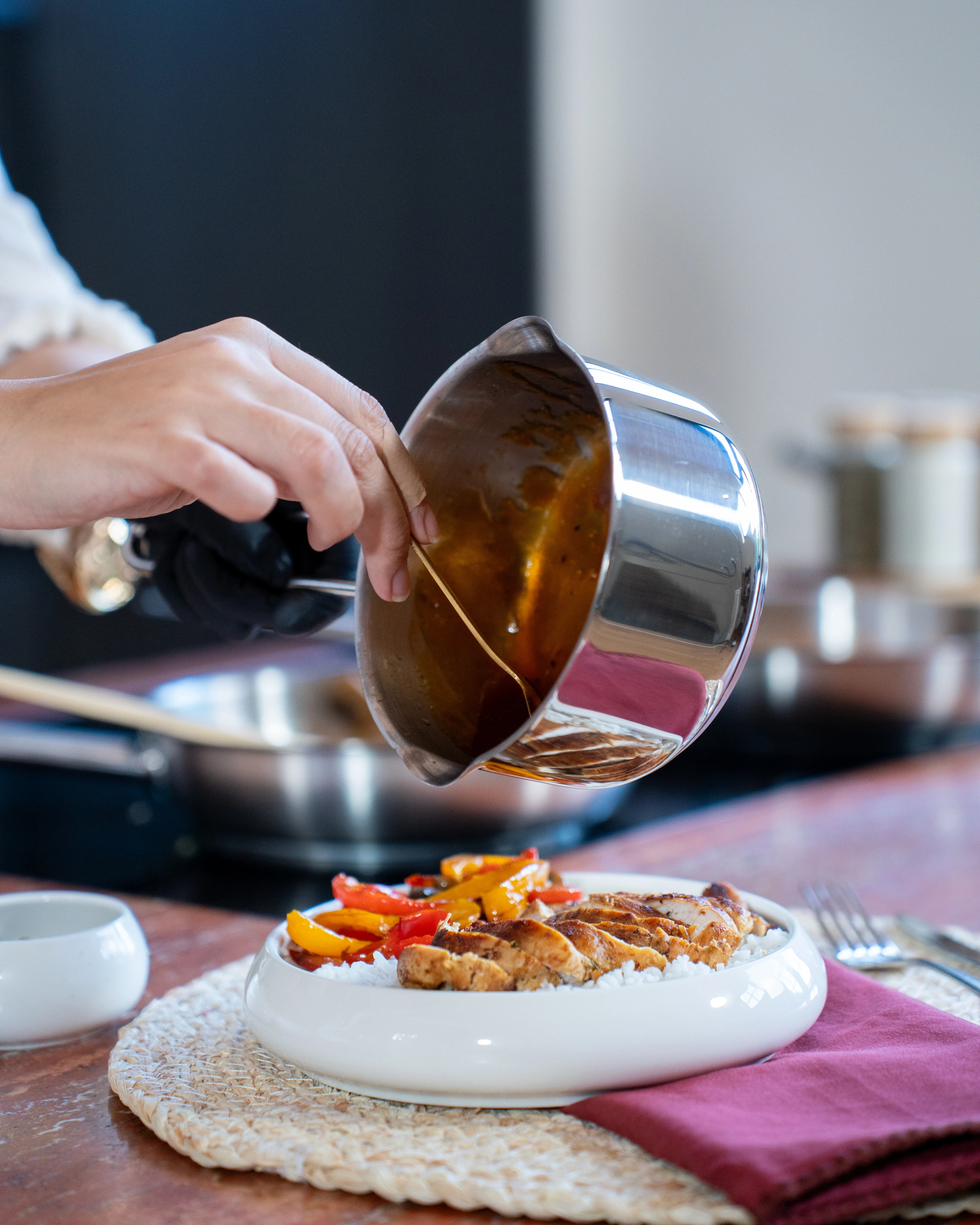 OYM olive oil in a cup with tomatoes and other vegetables on the side