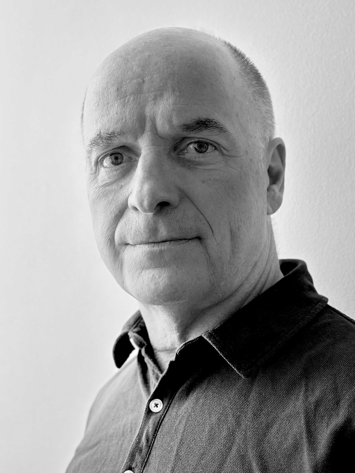 Retrato en blanco y negro de hombre rapado sin barba y camisa negra