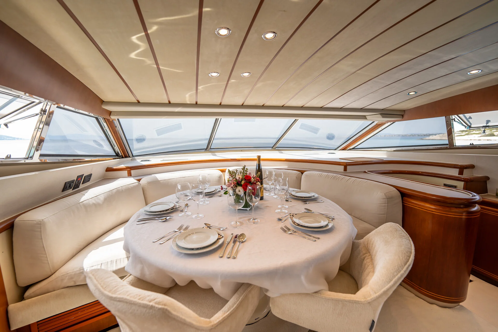 White Rock 36 speedboat with captain at helm cruising calm blue waters near Paros coastline with hills in background.