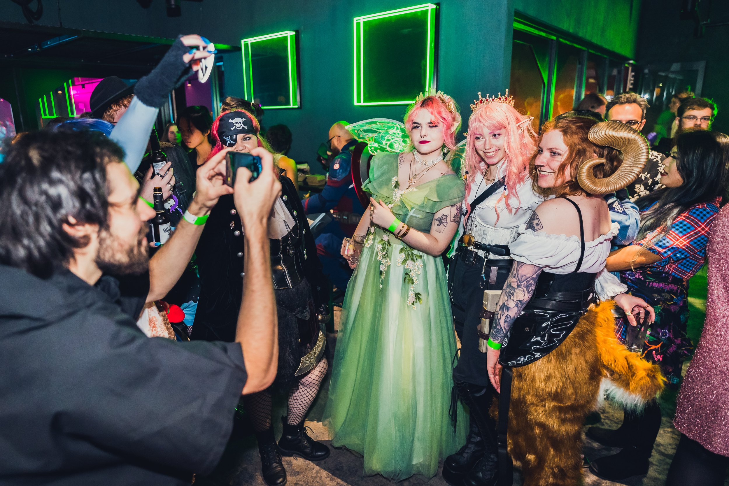 A group of people dressed in fantasy clothing, posing in front of a photographer