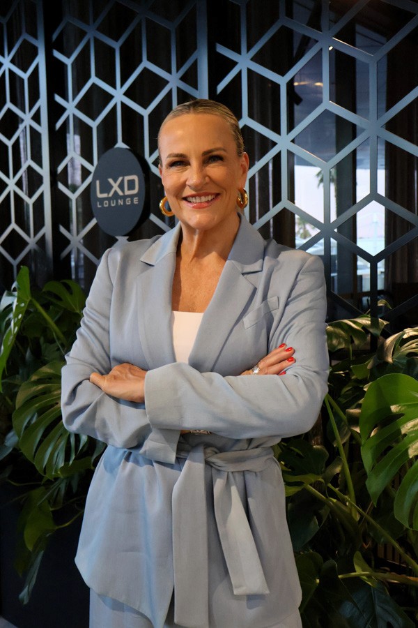 corporate portrait of a woman crossing her arms in a blue suit