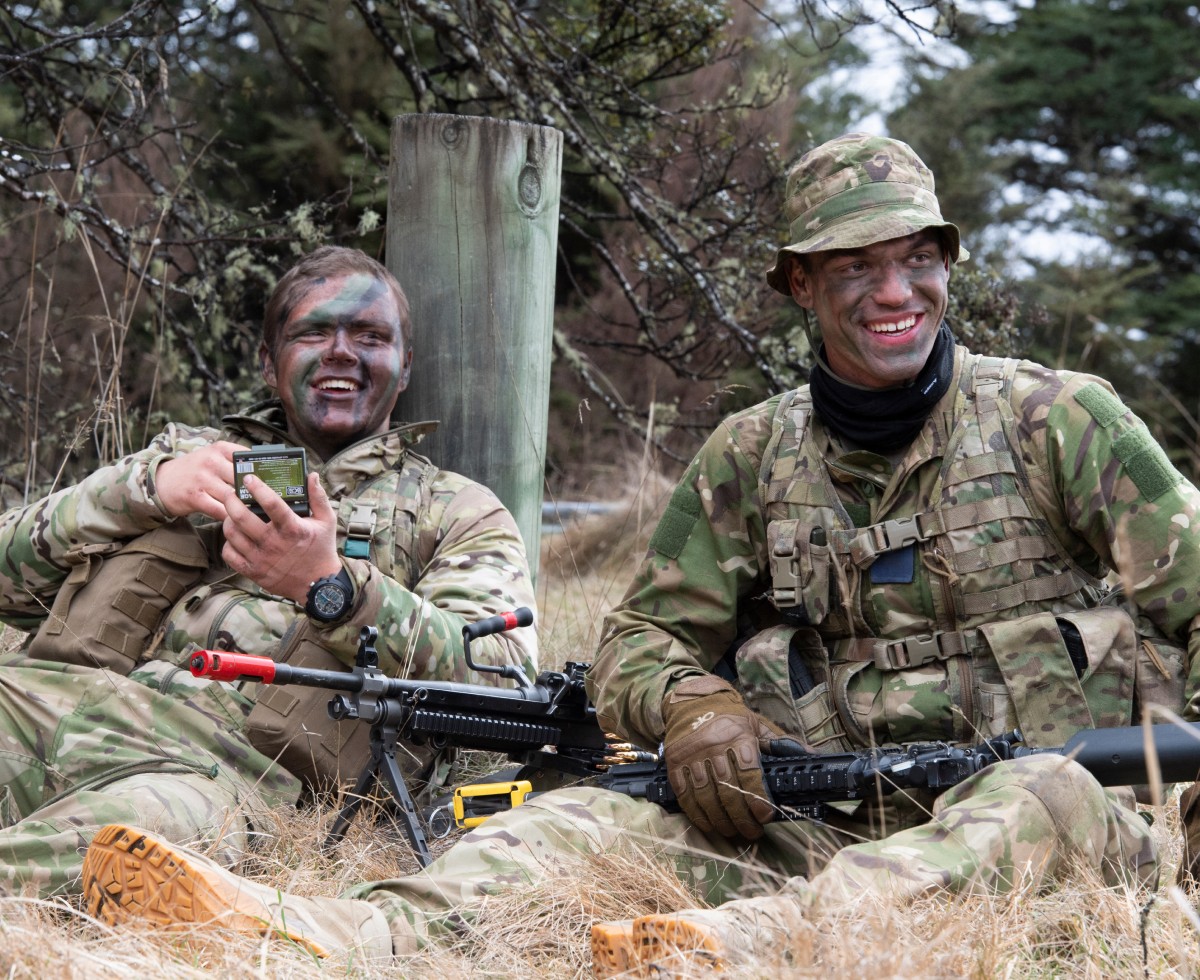 Two squadies sitting down and laughing while on training