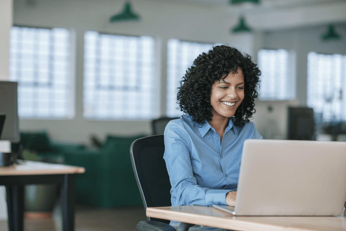 customer engagement software: Smiling woman using her laptop 