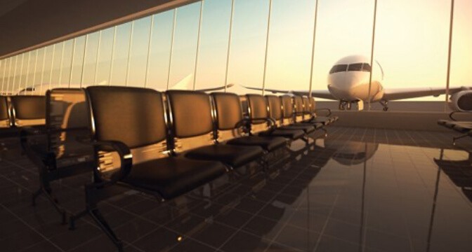 Airport waiting area with rows of empty seats and a plane visible through the windows.