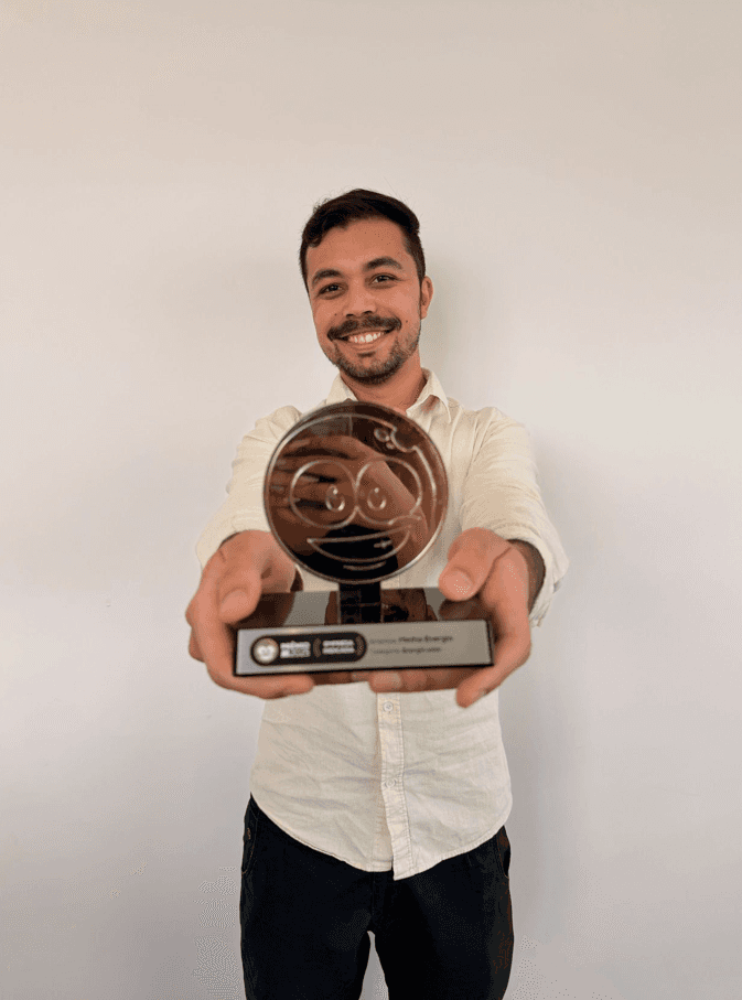 Funcionário da Metha Energia mostrando o Prêmio Reclame Aqui recebido