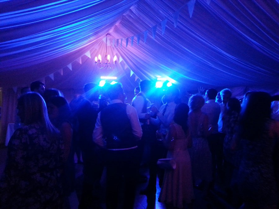 High-energy wedding dance floor with hands in the air