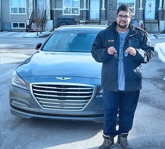 happy customer holding his new car keys infront of his car