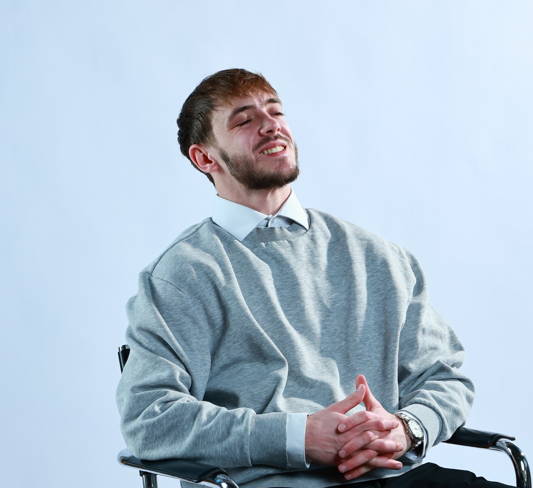 Woman working on a laptop computer at a table in a bright room.