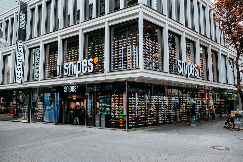 Corner view of a Snipes store with shoe displays and "RESERVED" sign.