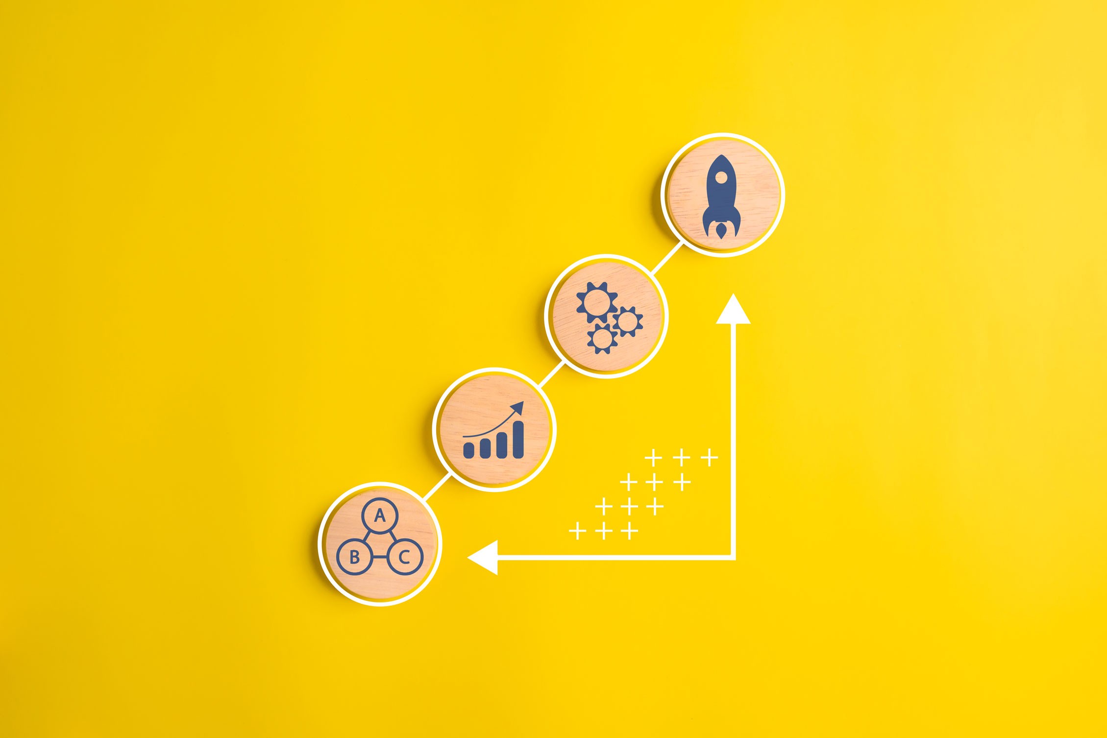 Drewniane okręgi z ikonami na żółtym tle symbolizujące kolejne etapy procesu tworzenia animacji 3D oraz rozwój projektu od wstępnej koncepcji po finalny render.