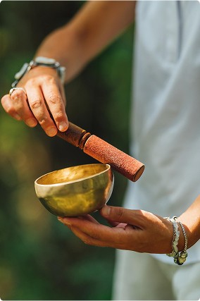 A beautifully arranged spread of Ayurvedic meals featuring fresh salads, sliced mushrooms, colorful cherry tomatoes, boiled eggs, and leafy greens, complemented by a wooden mortar and pestle on a rustic wooden table.