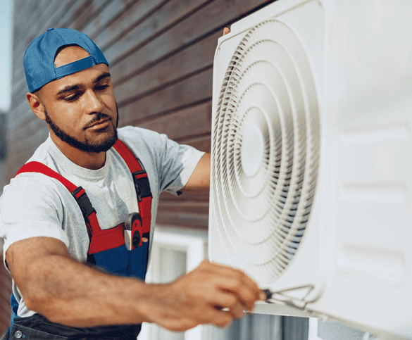 Technician repairing heat pump in in backyard of Toronto home