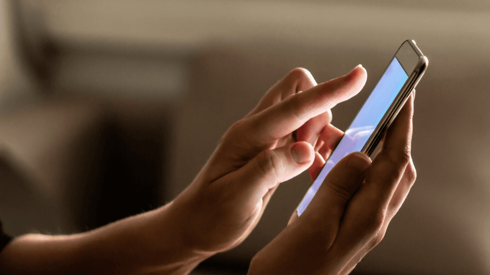 A woman using the StoreHub Manager App on her iPhone