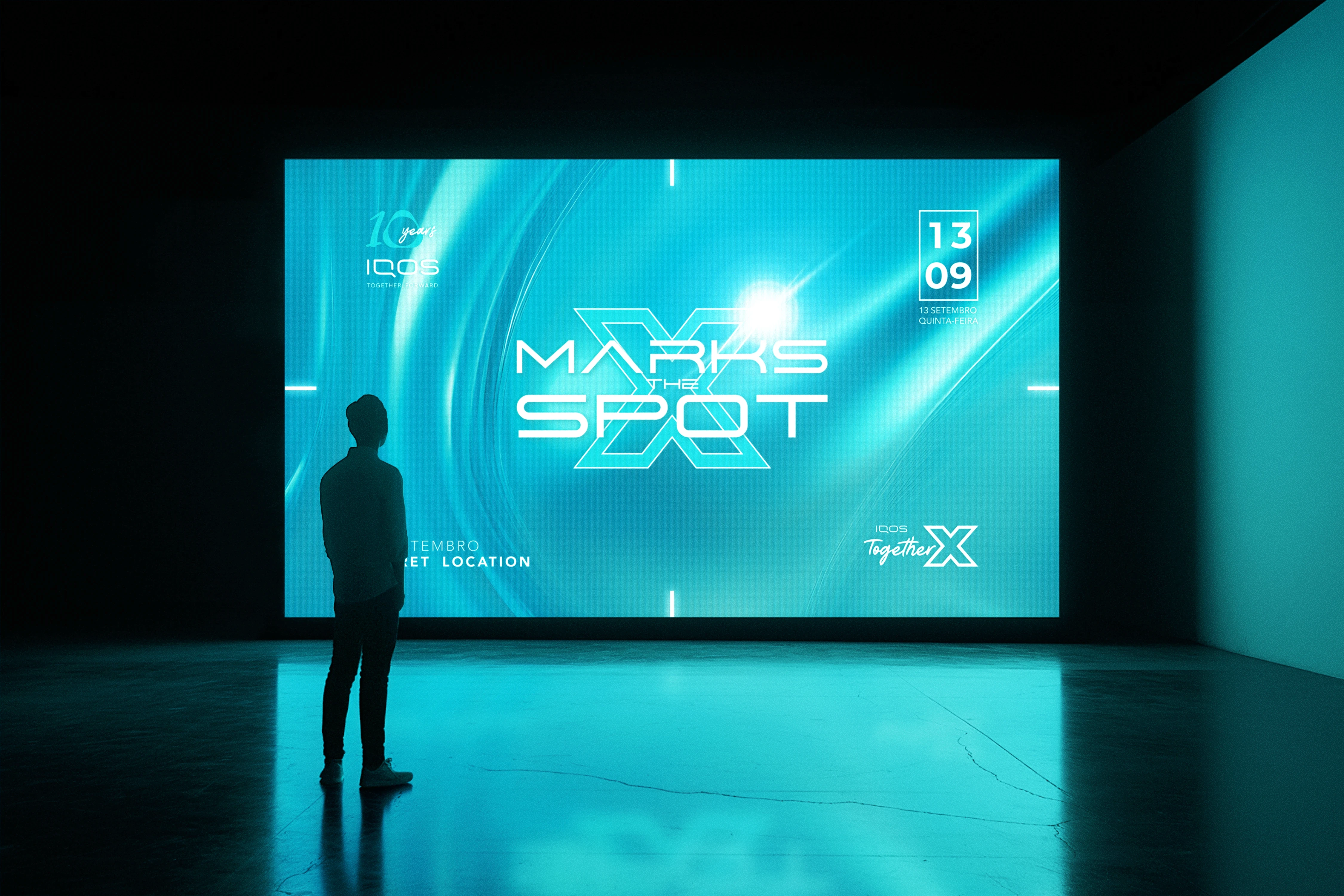 Immersive event screen design for the IQOS 10 Years celebration, showing the “Marks the Spot X” visual identity on a large LED wall with futuristic turquoise lighting and spatial branding.