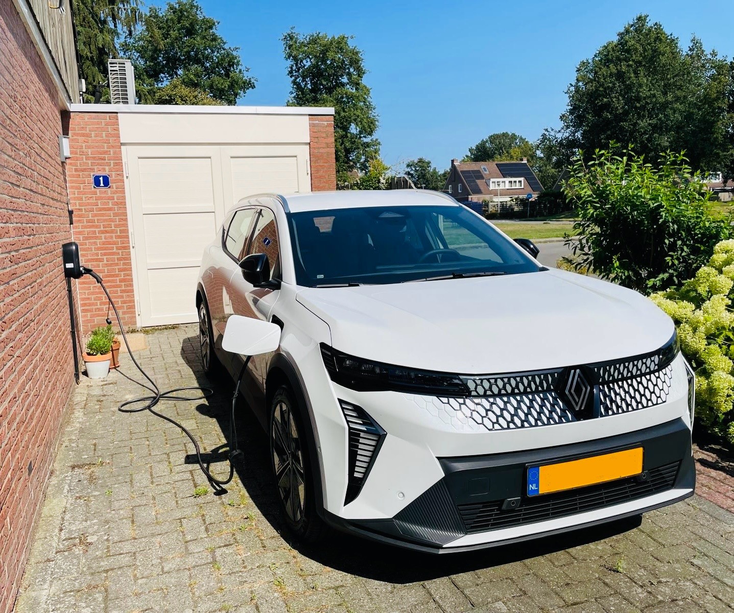 elektrische auto aan het laden op een oprit