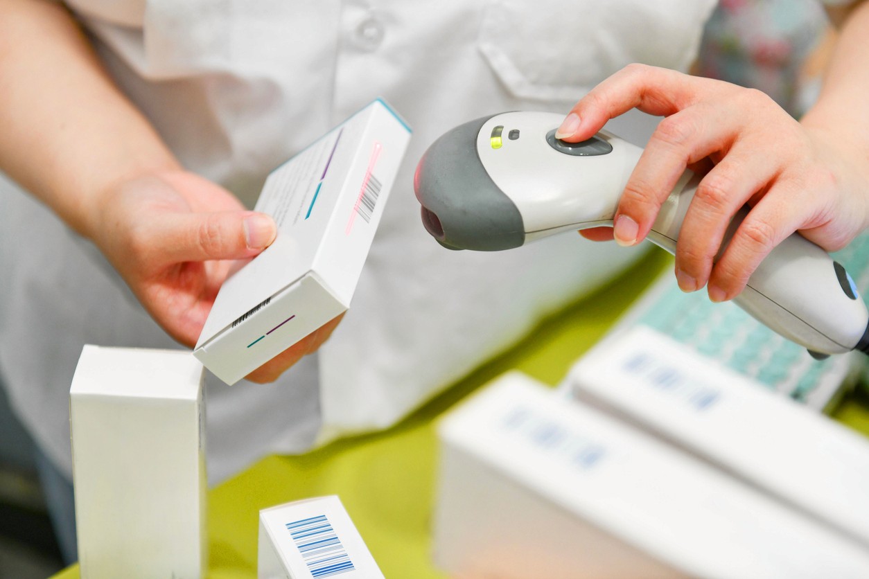 A healthcare worker scans a unique device identifier barcode on a medical device package at point of care.