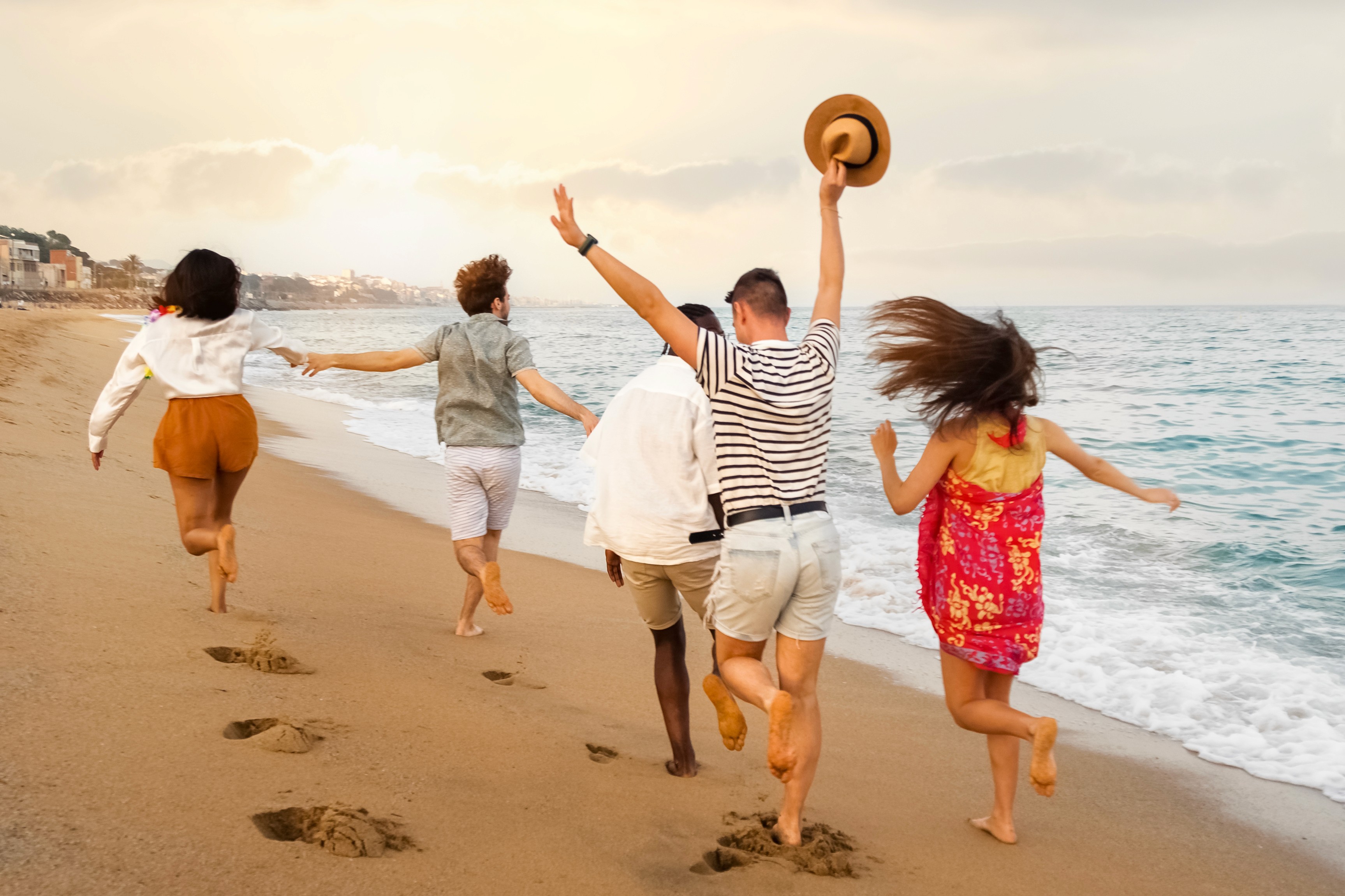 5 people running on the beach