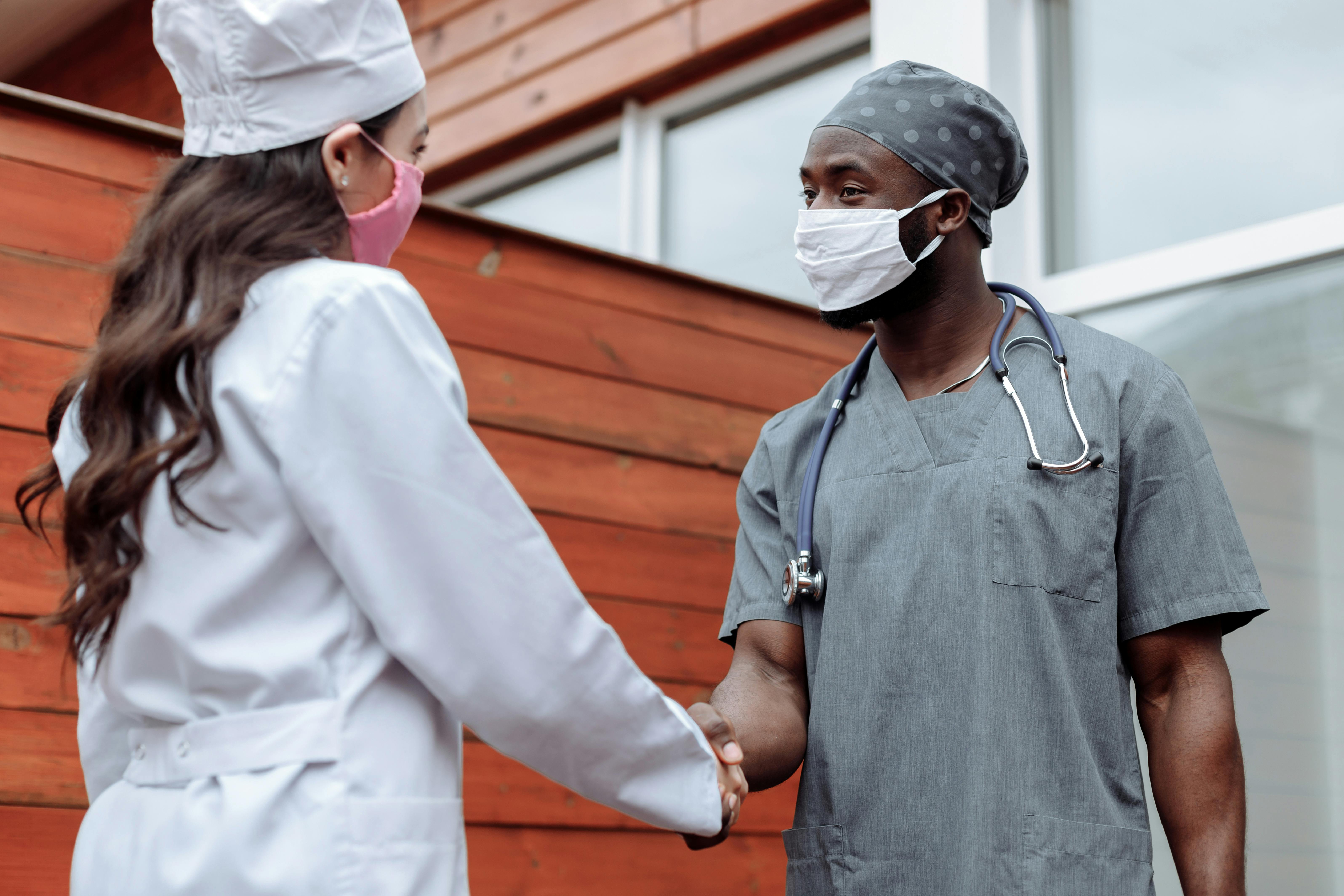 Doctors in masks shaking hands