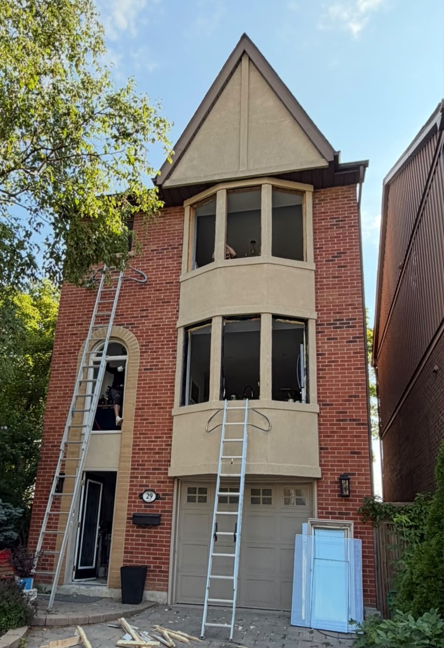 Before window replacement: red brick house with old bay windows in Toronto