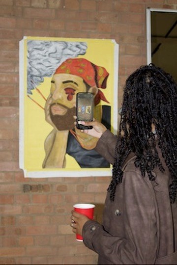 Visitor photographing an exhibited artwork