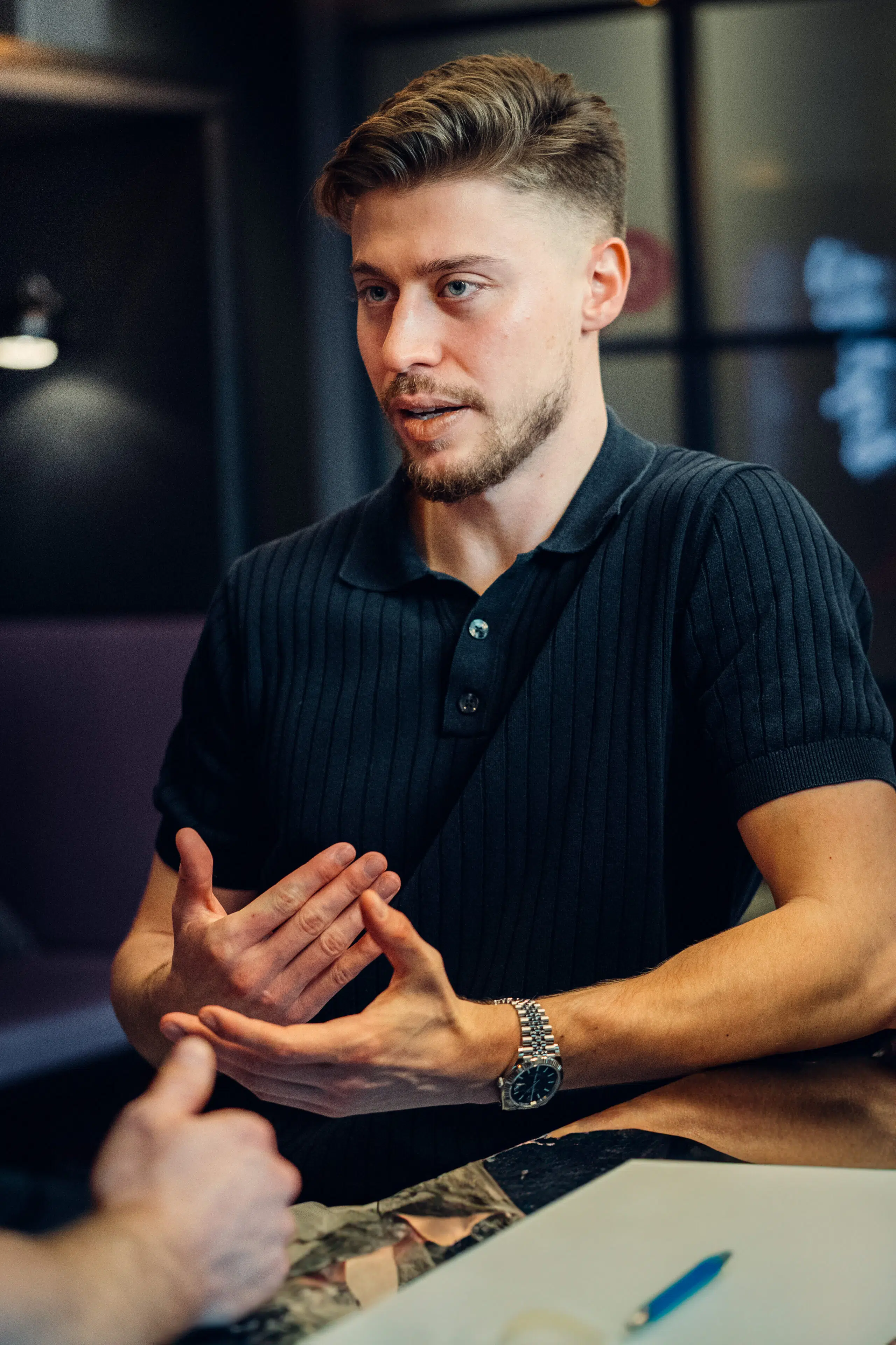 Junger Mann im Gespräch, Hände gestikulierend. Business oder Interview.