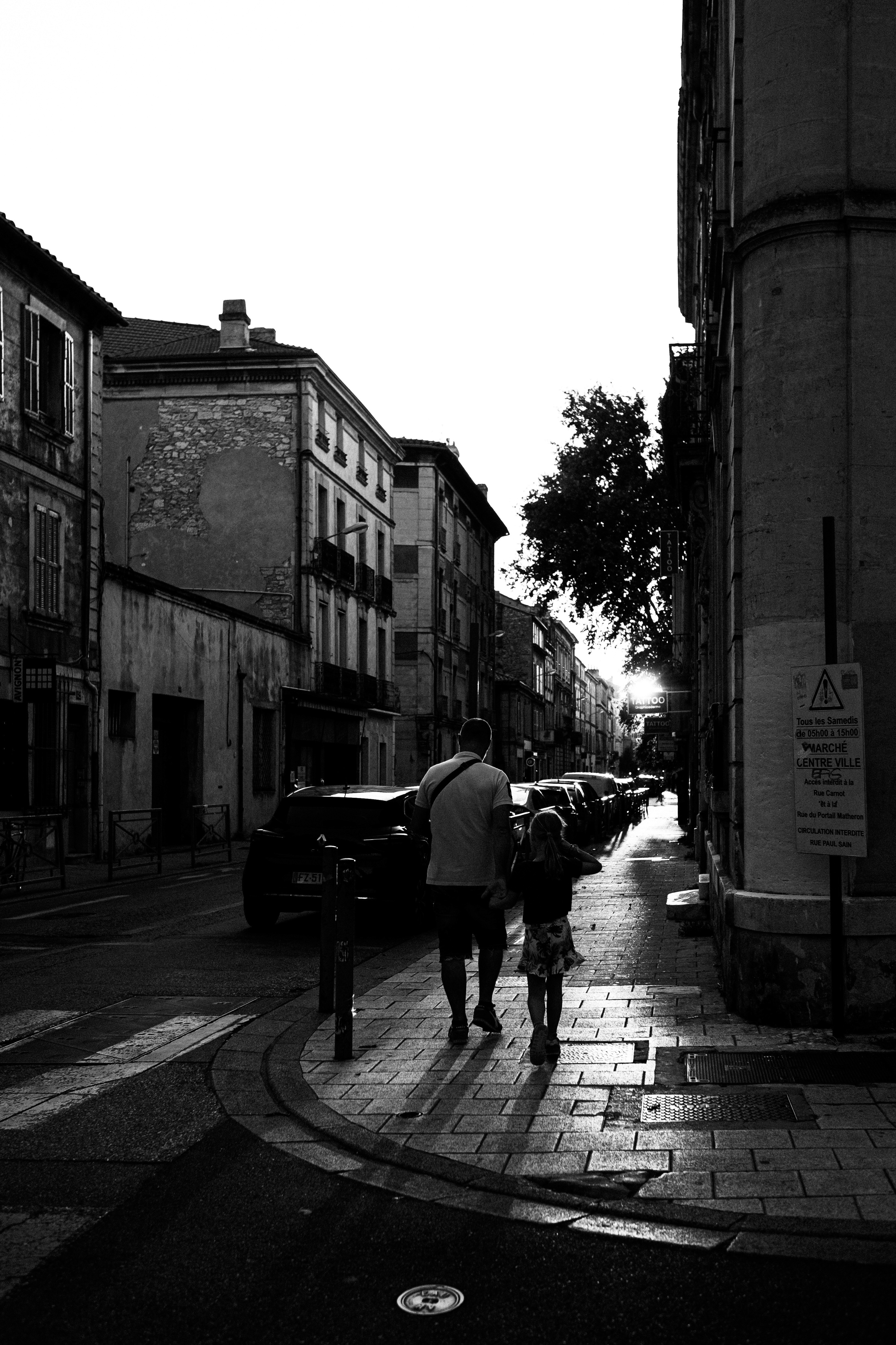 Two people walking on the street at sunset