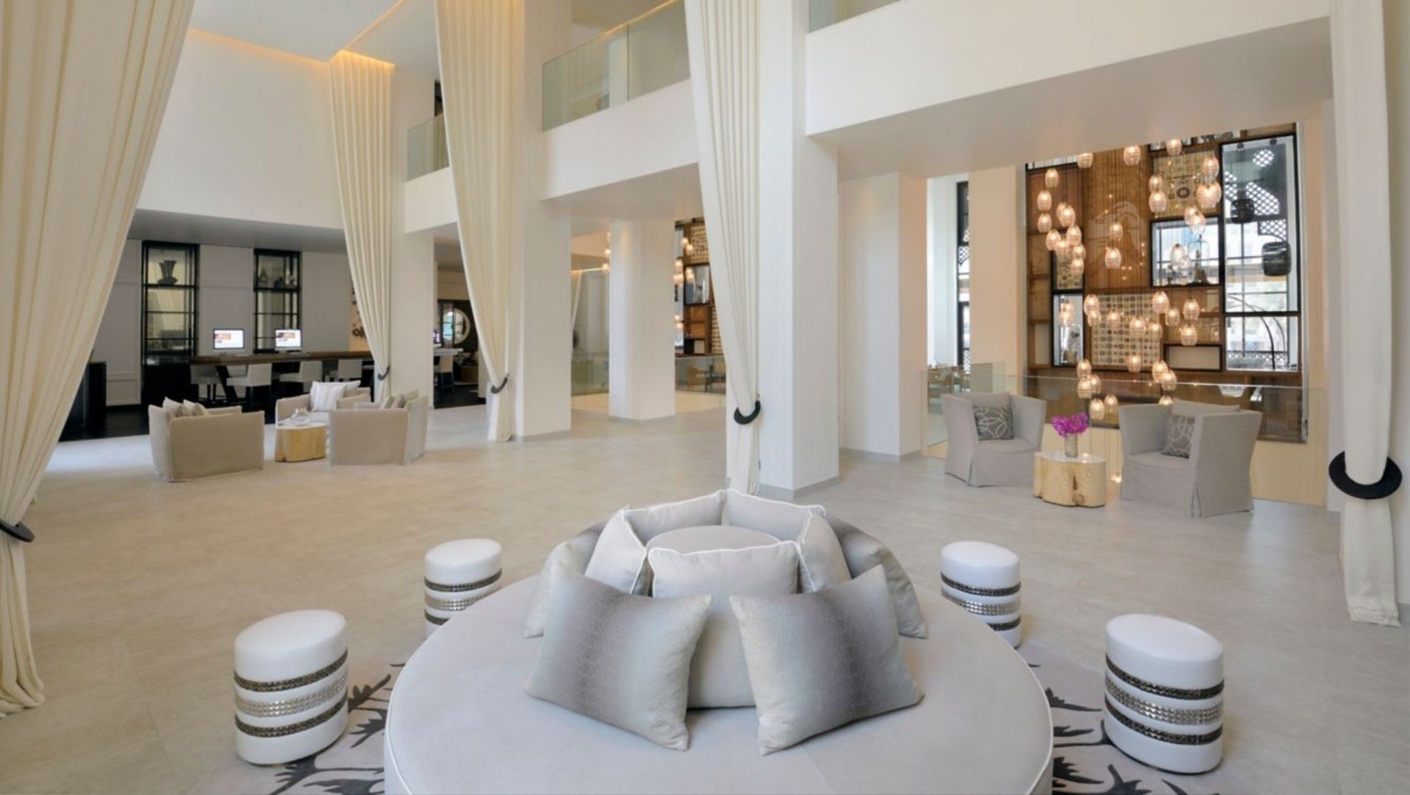 The lobby of Hotel Boulevard, Autograph Collection, feautring white and beige colors, with seating areas and curtains.