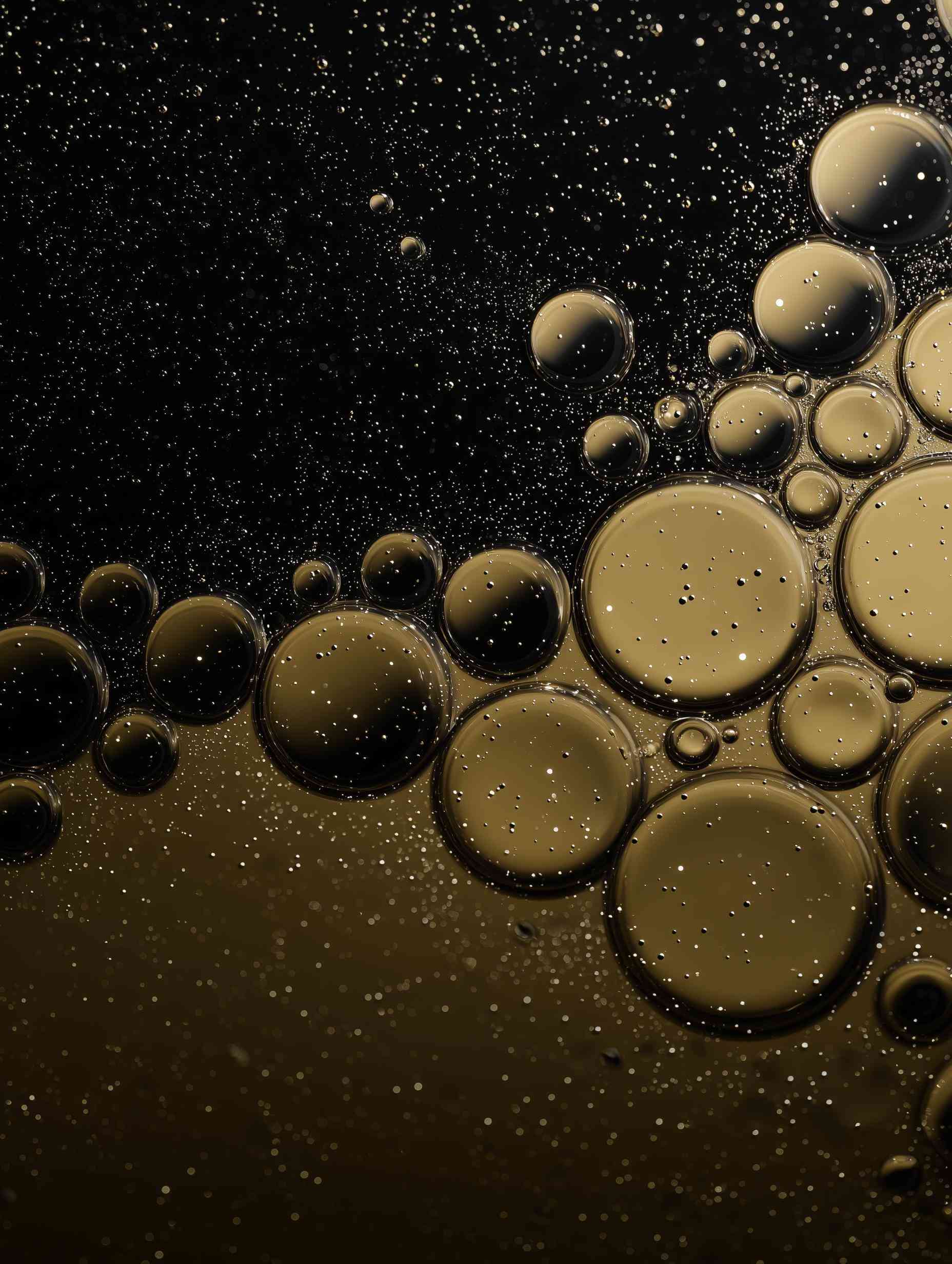 Oil bubbles and foam on yellow and black liquid