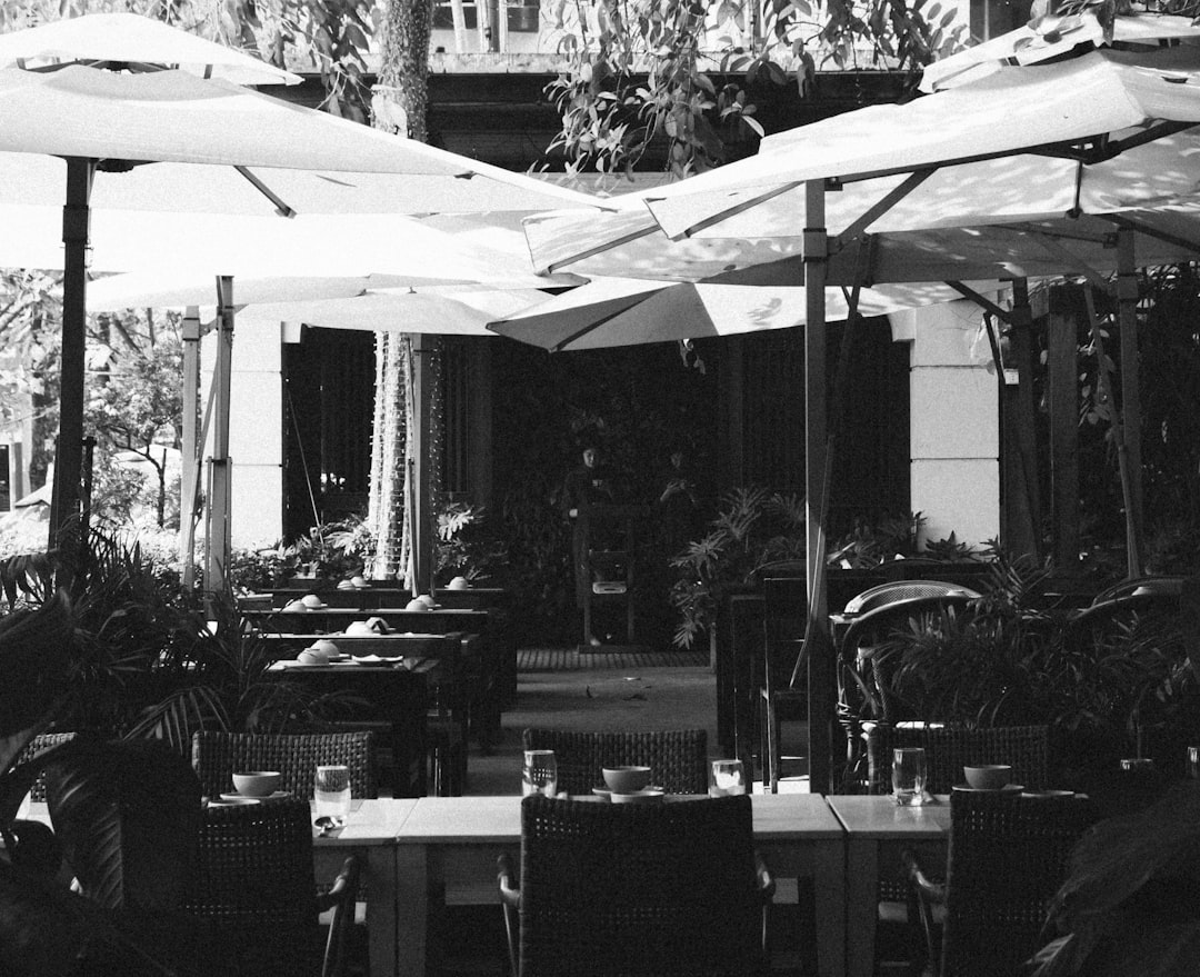 Outdoor cafe tables with umbrellas and plants