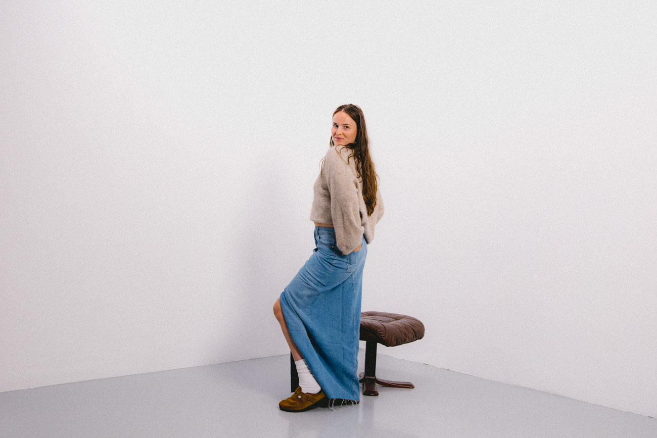 Girl standing in white room posing to have her photo taken
