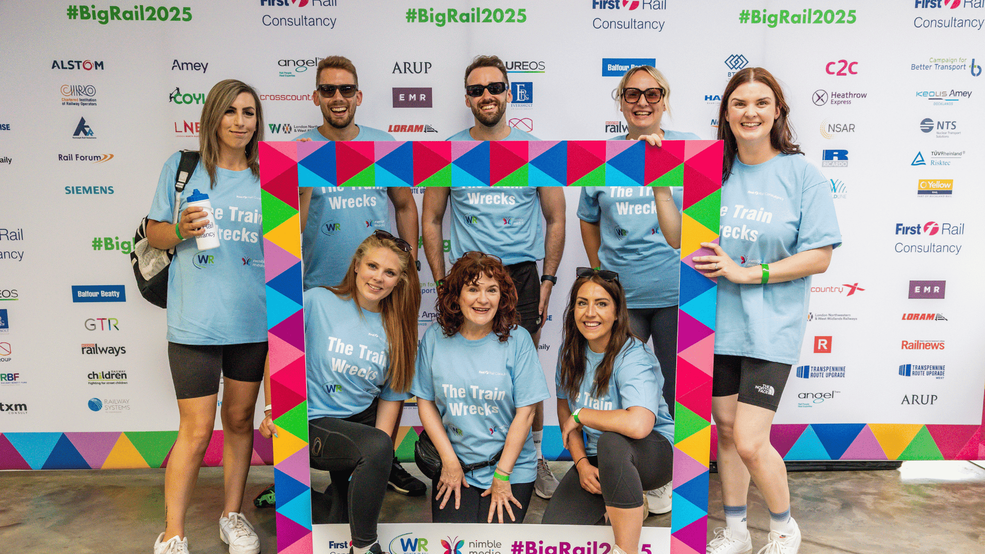 Outdoor team-building event with participants wearing matching blue shirts, taking part in inflatable obstacle courses and games, smiling and cheering, with the words 'ENTER A TEAM' in large bold white and green text across the image.