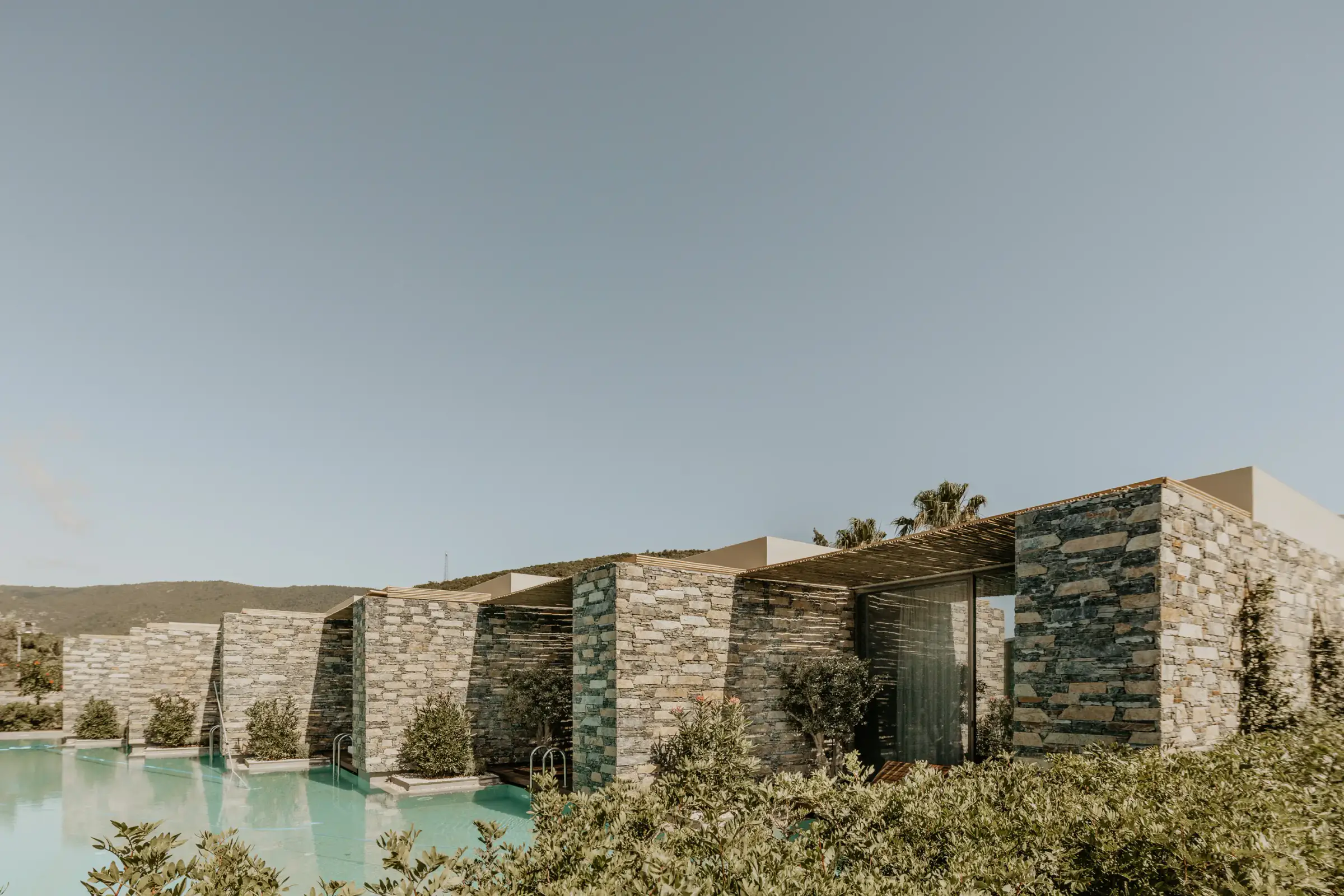 Poolside rooms seen beyond planting