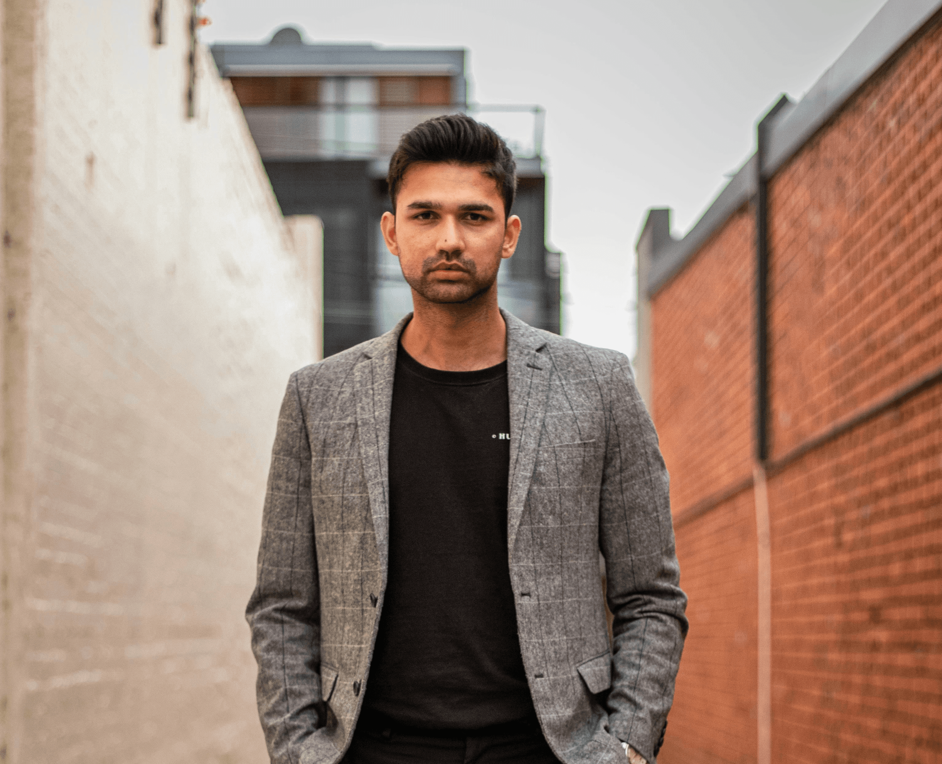 man in gray suit jacket and black pants standing on brown concrete pathway during daytime