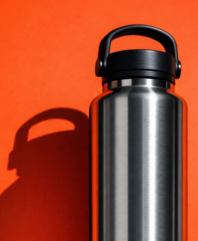 Stainless steel water bottle on orange background