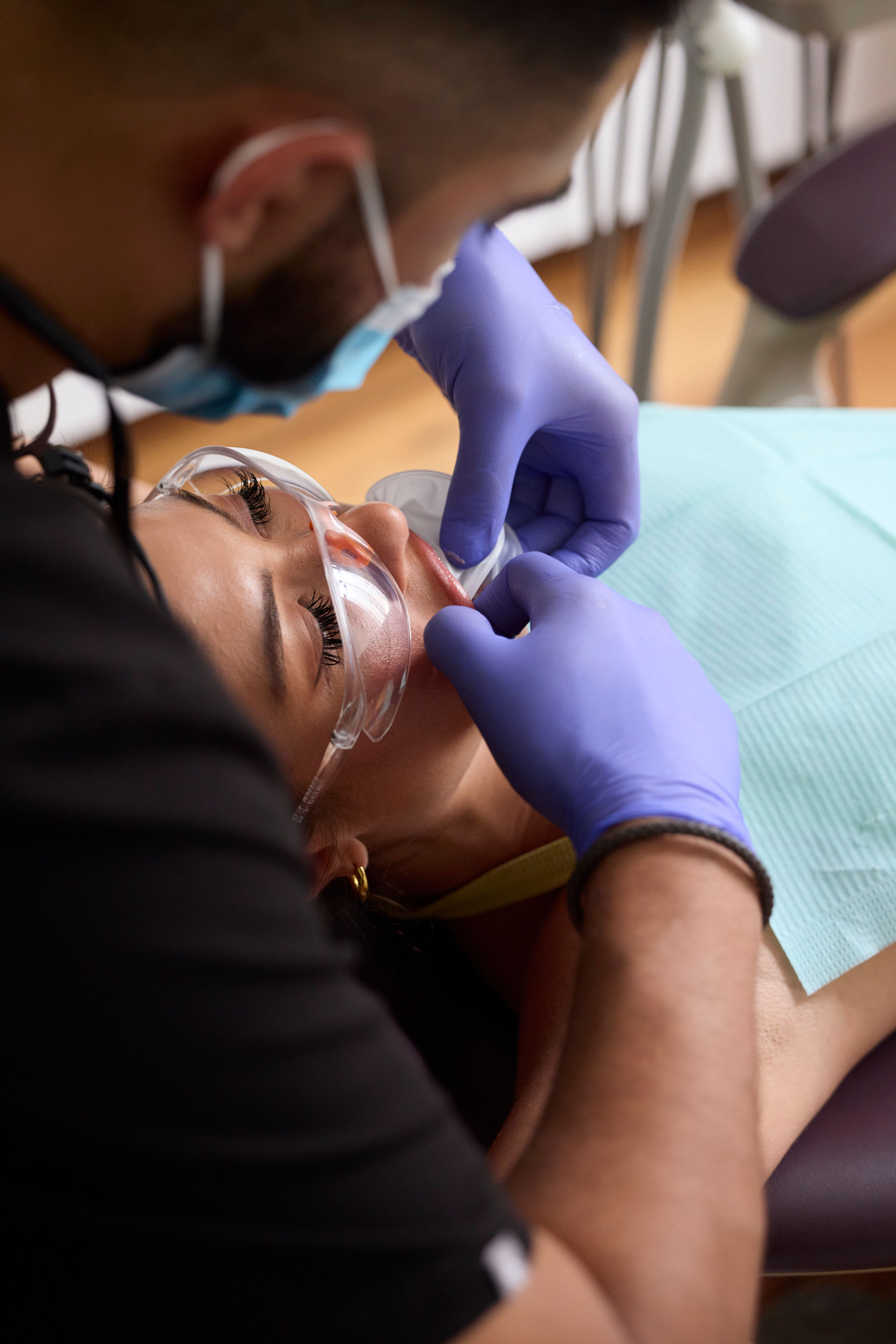 Silhouette of a person standing by a window with red-tinted light, plants nearby.