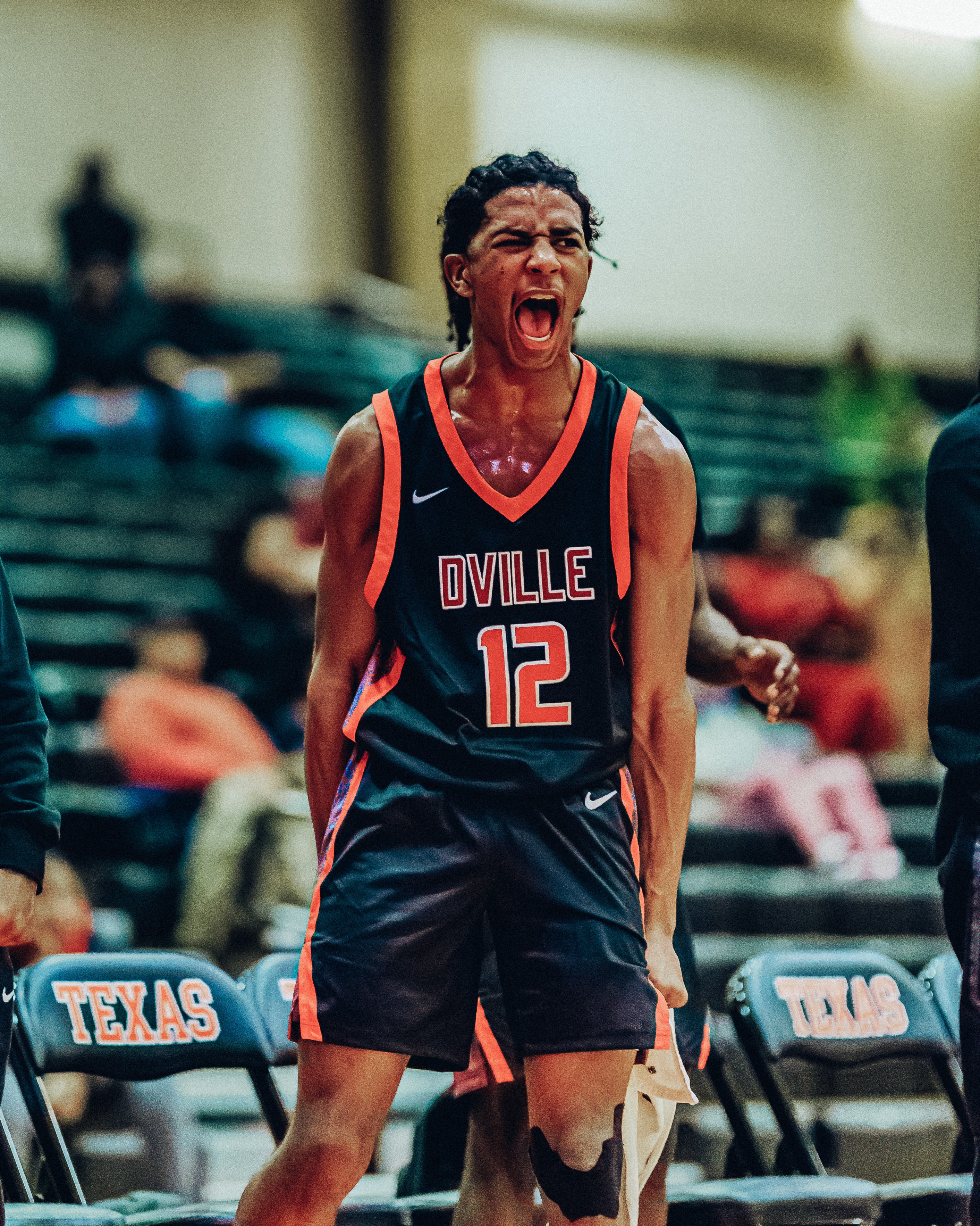 Three people sitting on a couch in a room looking at mobile devices