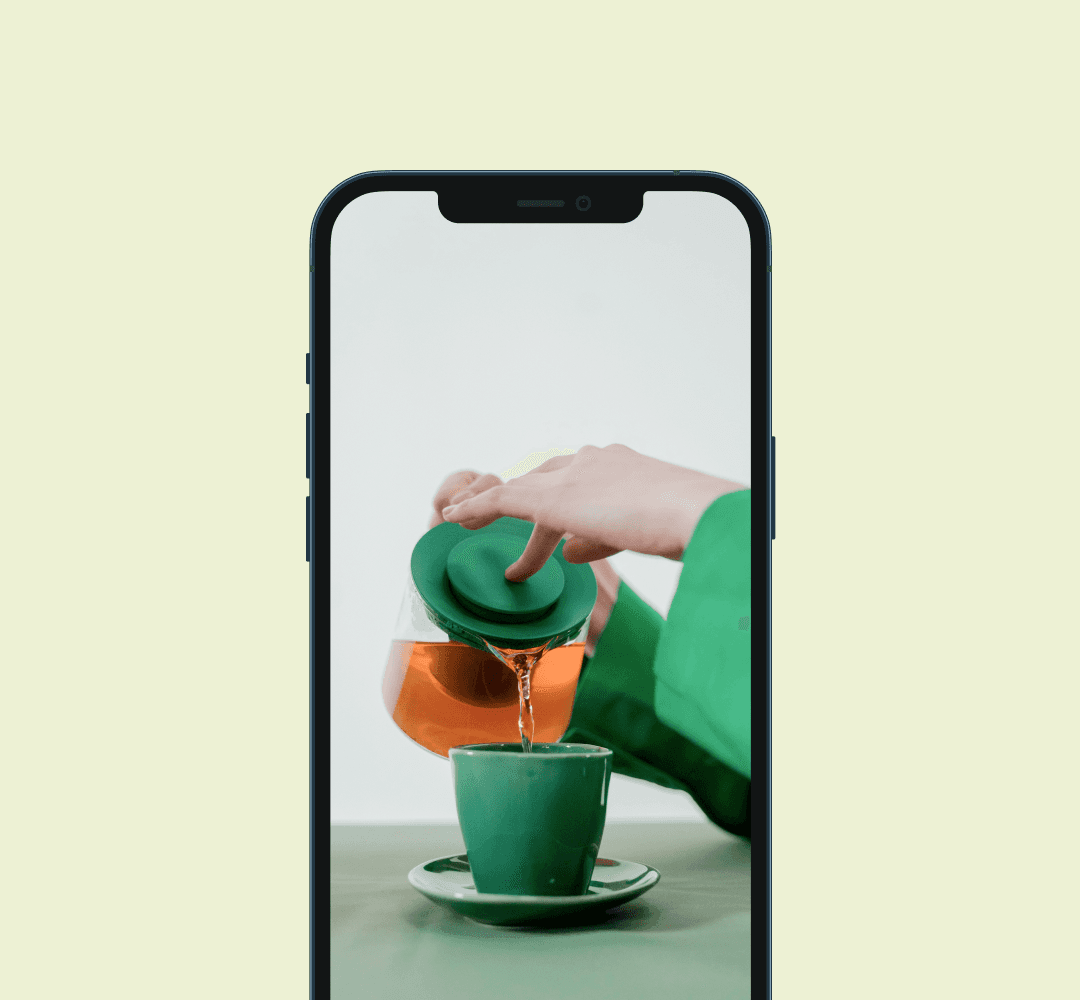 A mockup of a phone displaying an image of a woman pouring tea