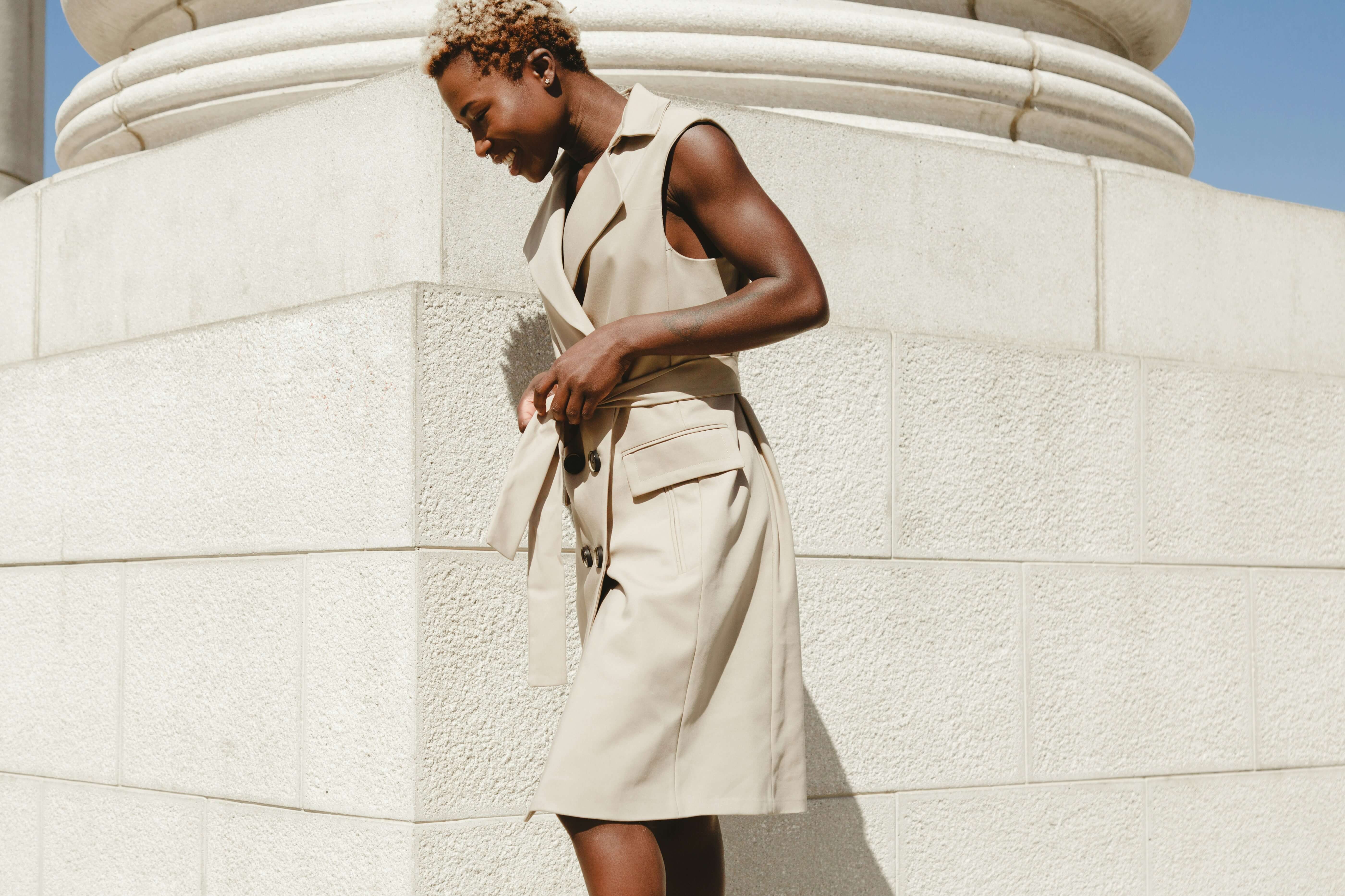 woman looking down next to column