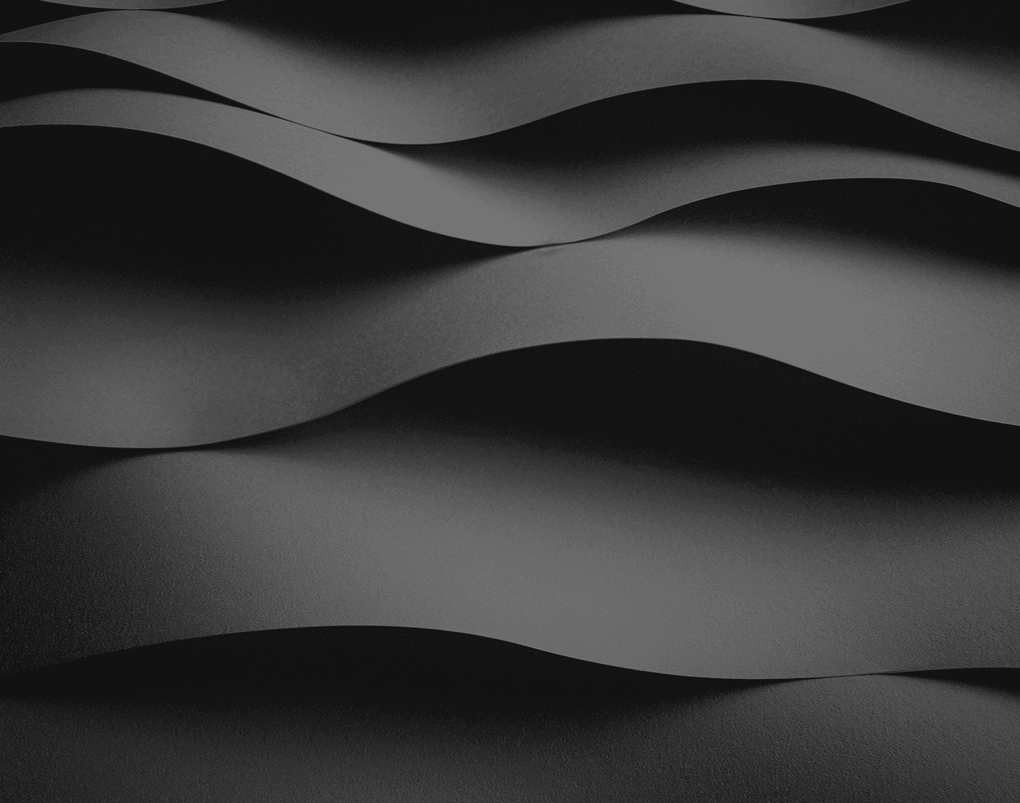 Abstract flowing waves in grayscale creating a smooth, undulating pattern with light and shadow gradients