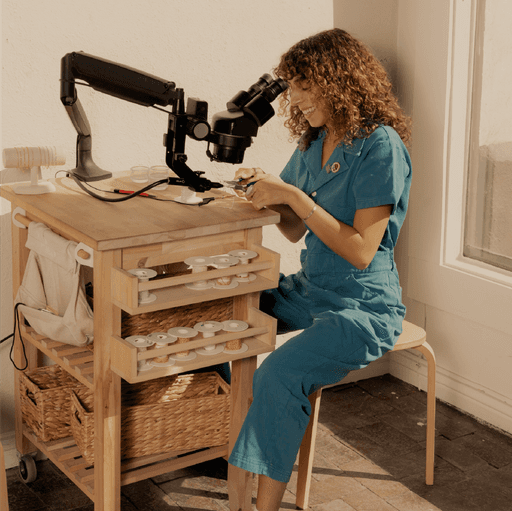 staff looking into a microscope for permanent jewelry