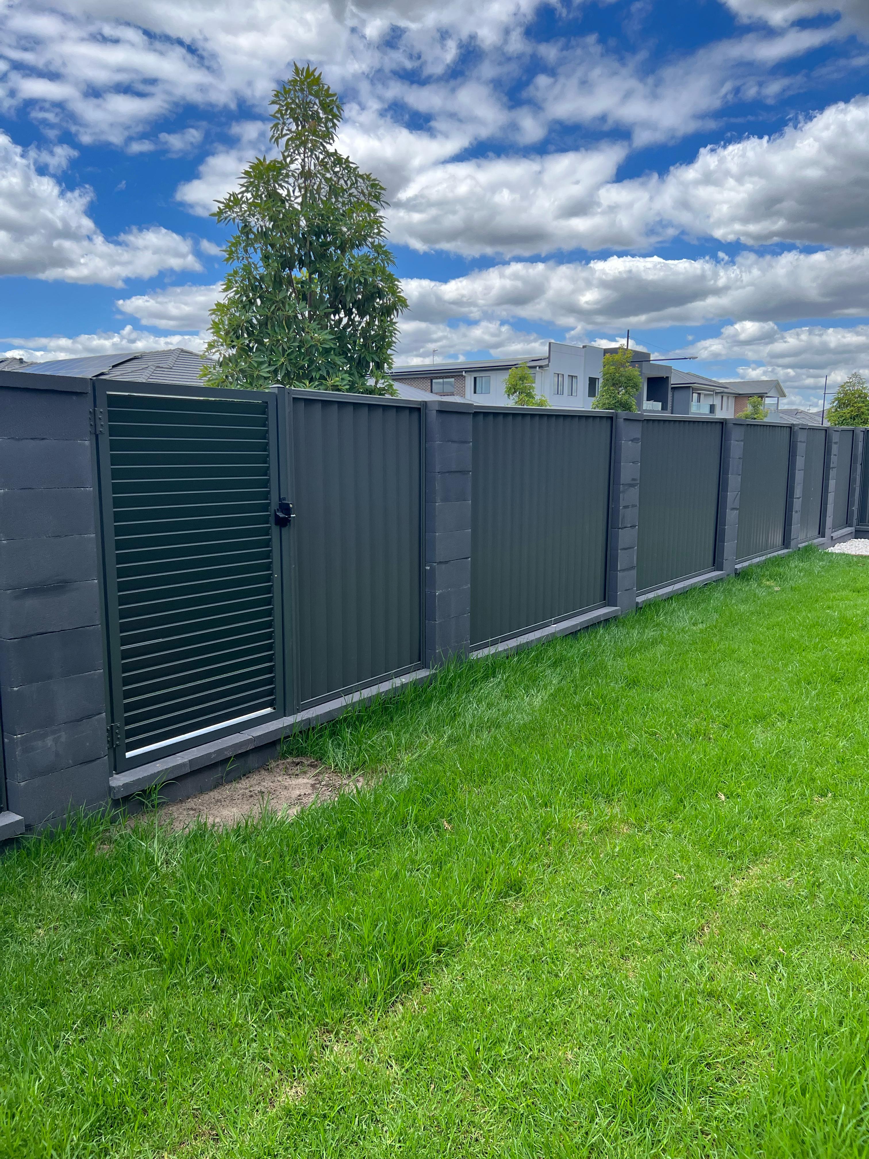 Aluminium fence with privacy panels and side gate on concrete base, durable low-maintenance boundary for modern homes